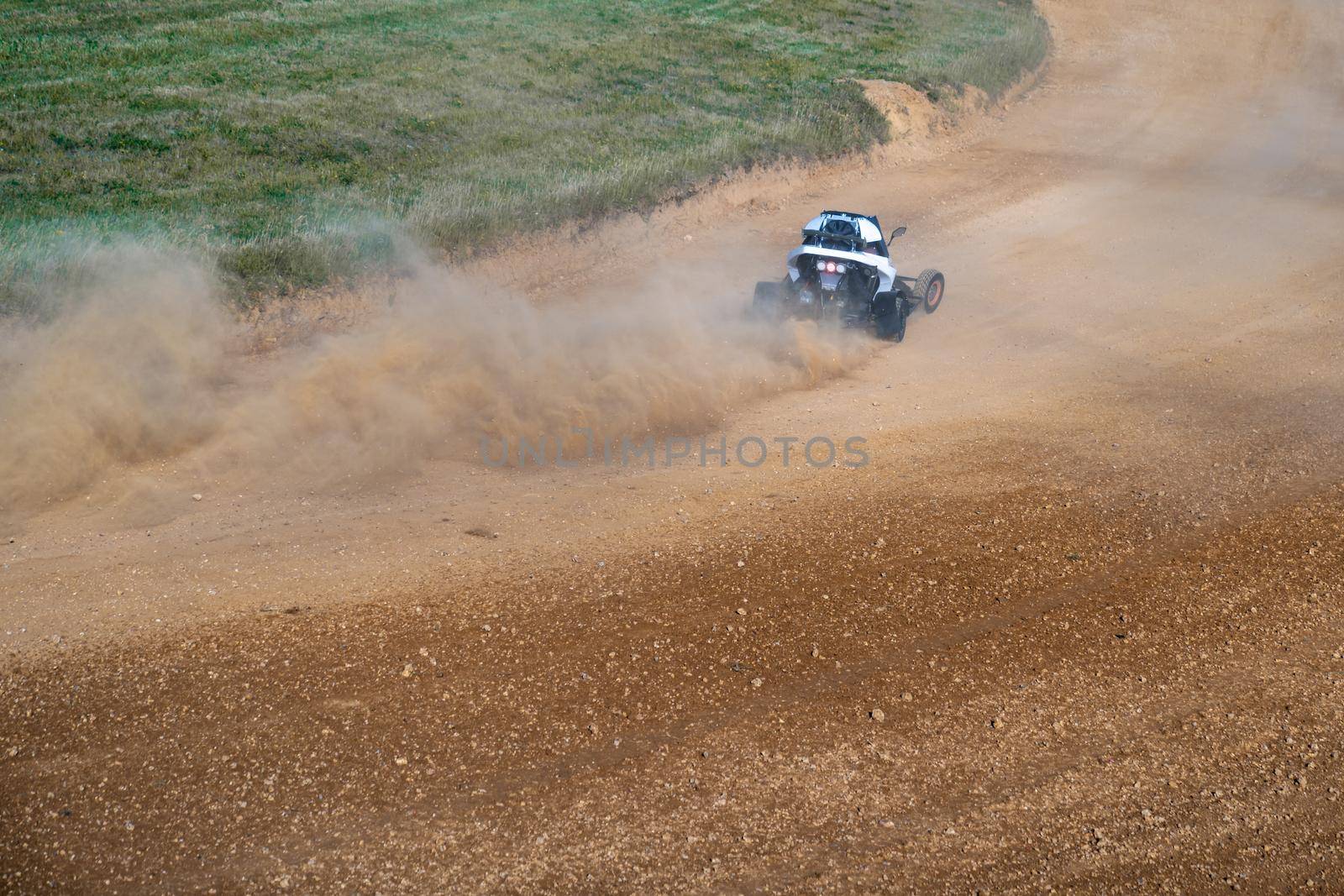 buggies on the autocross track, skidding, dust and dirt flying under the tires.