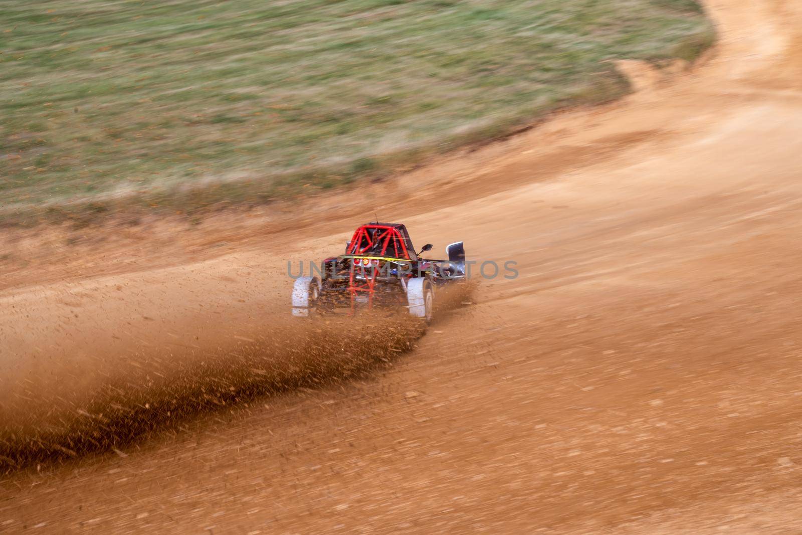 buggies on the autocross track, skidding, dust and dirt flying under the tires.
