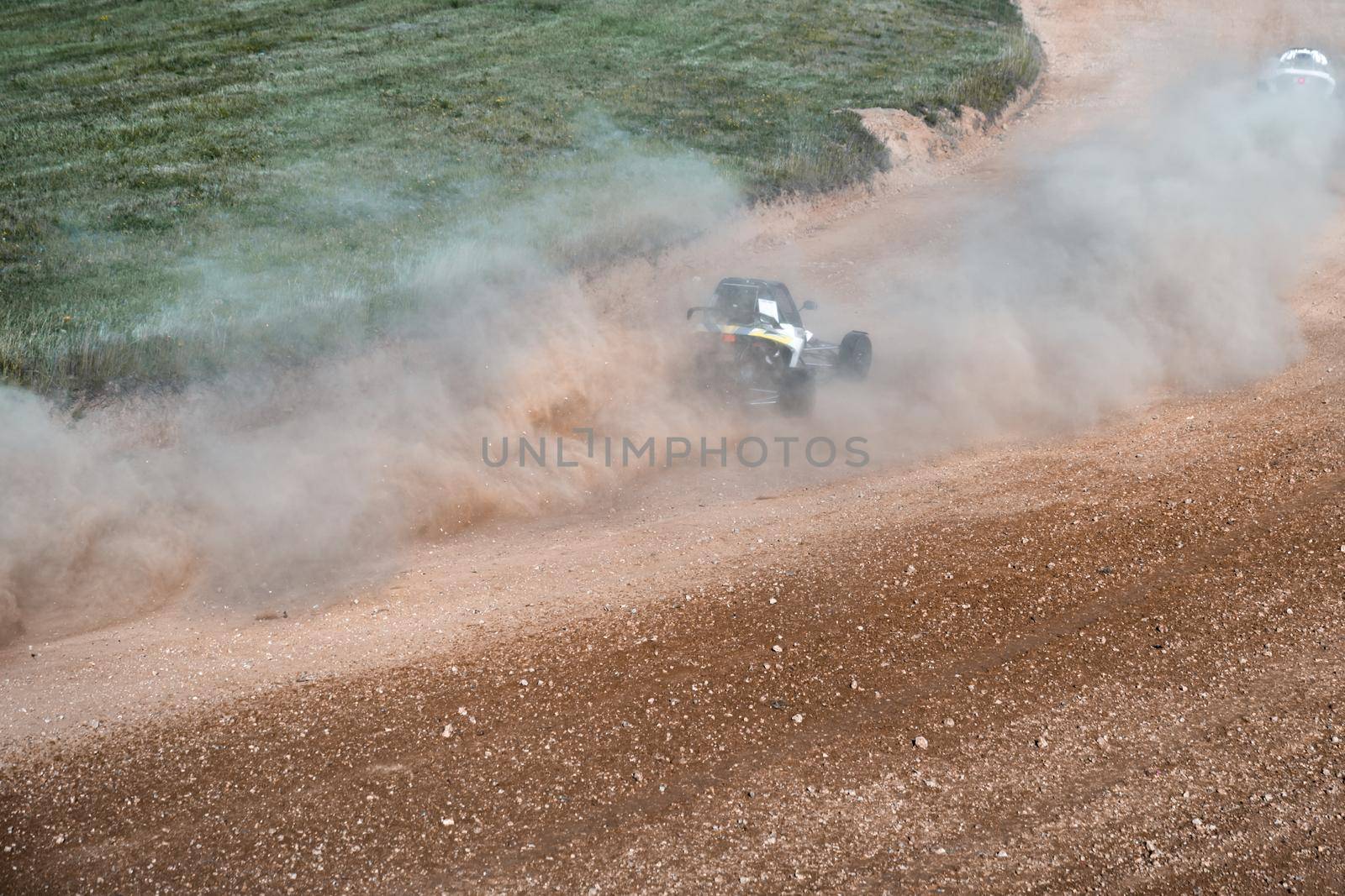 buggies on the autocross track, skidding, dust and dirt flying under the tires.