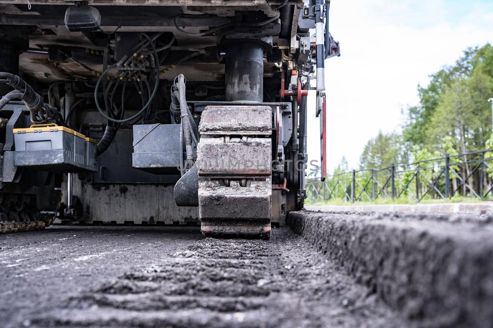 rear view of a cold milling machine and cut asphalt on the road. Road works. During the repair, a layer of old asphalt was removed.