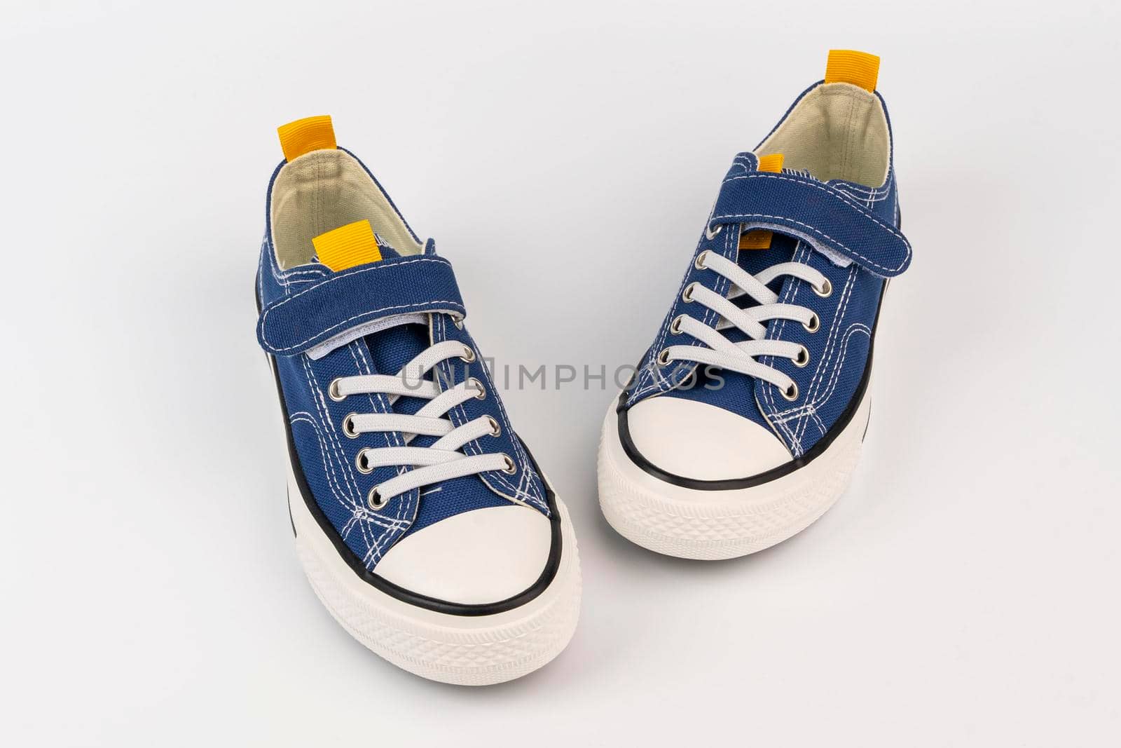 a pair of blue sneakers on a white background. Classic athletic shoes. Fashionable youth shoes. front view from above. copy space