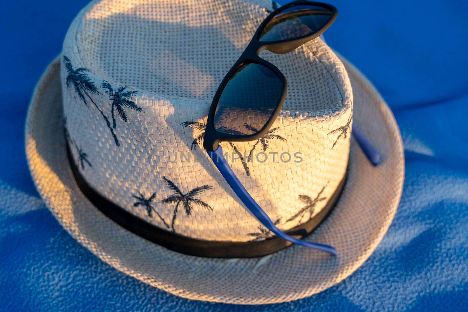 a sun hat and sunglasses on a beach blanket. The concept of summer holidays, vacations and travel. Copy space