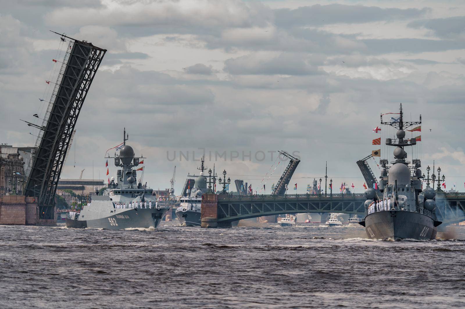 Russia, St. Petersburg, 28 July 2022: A lot of warships goes along the Neva River under open bridges at the time of the rehearsal of the celebration of the day of the Navy in sunny weather. High quality photo