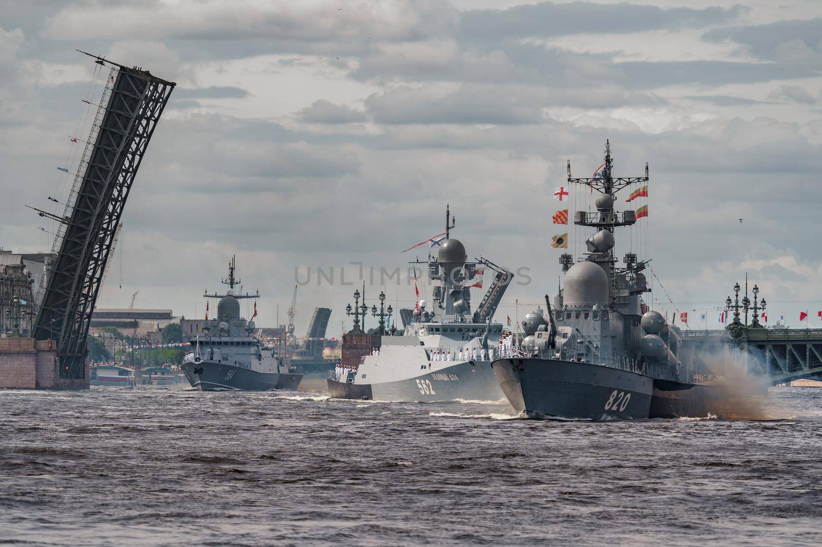 Russia, St. Petersburg, 28 July 2022: A lot of warships goes along the Neva River under open bridges at the time of the rehearsal of the celebration of the day of the Navy in sunny weather. High quality photo