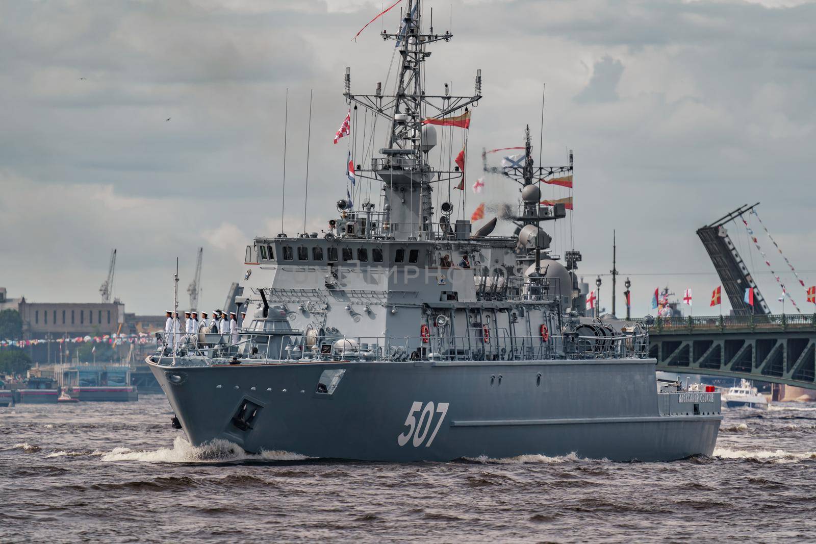 Russia, St. Petersburg, 28 July 2022: A lot of warships goes along the Neva River under open bridges at the time of the rehearsal of the celebration of the day of the Navy in sunny weather. High quality photo