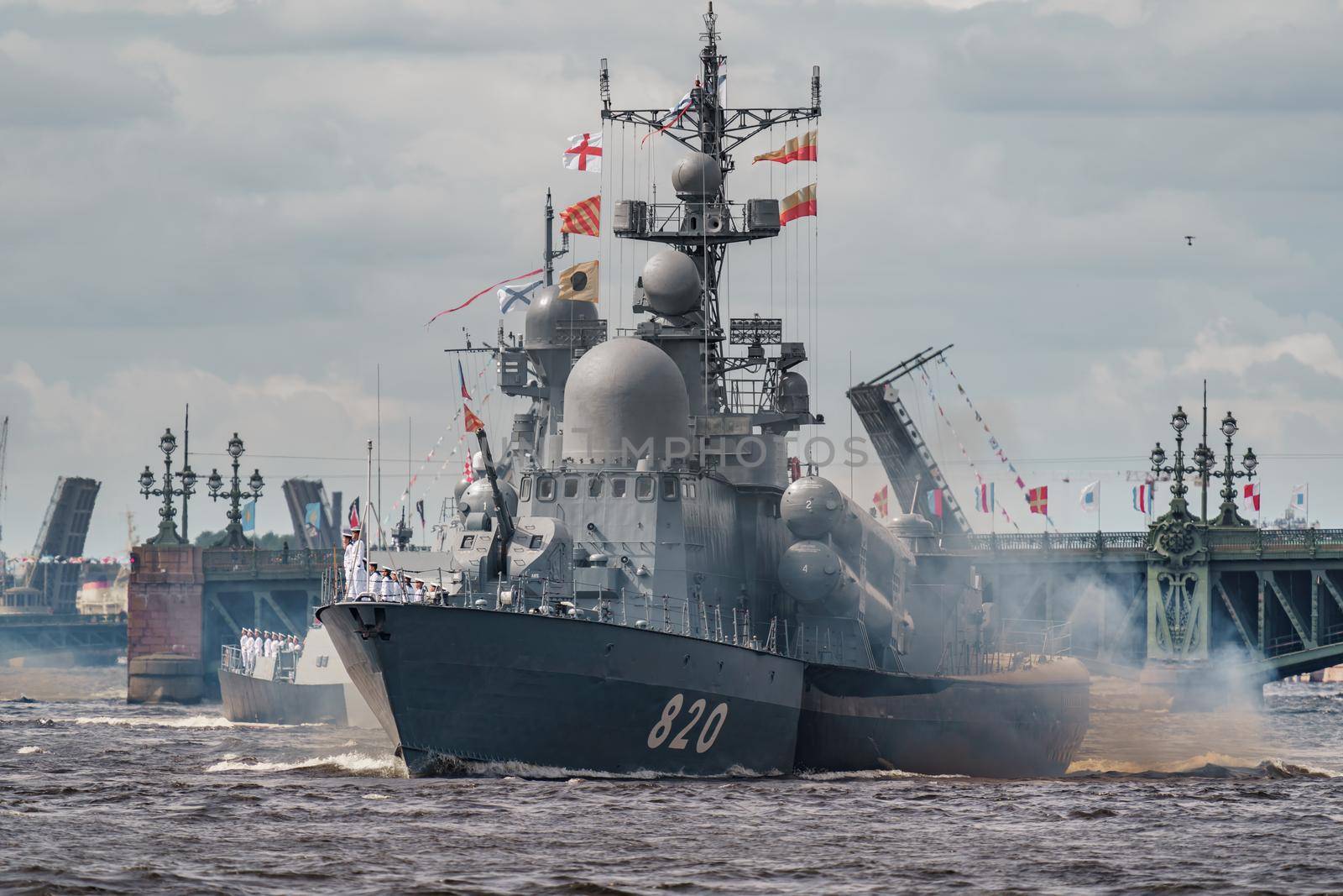Russia, St. Petersburg, 28 July 2022: A lot of warships goes along the Neva River under open bridges at the time of the rehearsal of the celebration of the day of the Navy in sunny weather. High quality photo