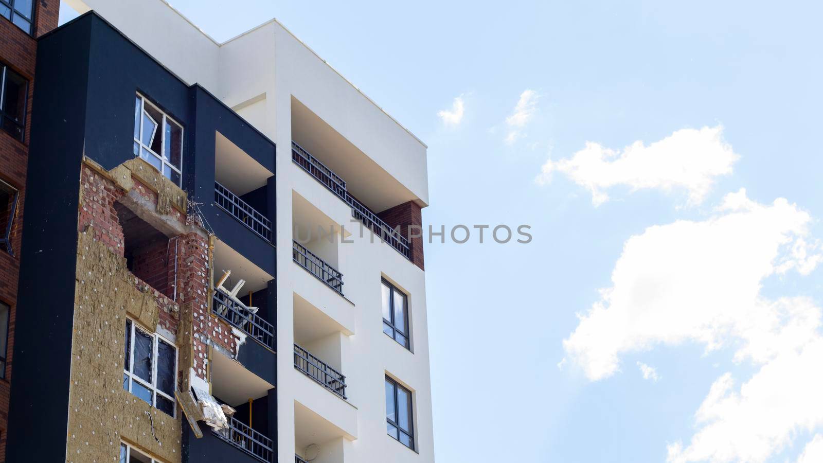 A residential building was damaged after being hit by a rocket. Holes from shells in a multi-storey building. Consequences of the war with Russia. Terrible destruction of the building by shells