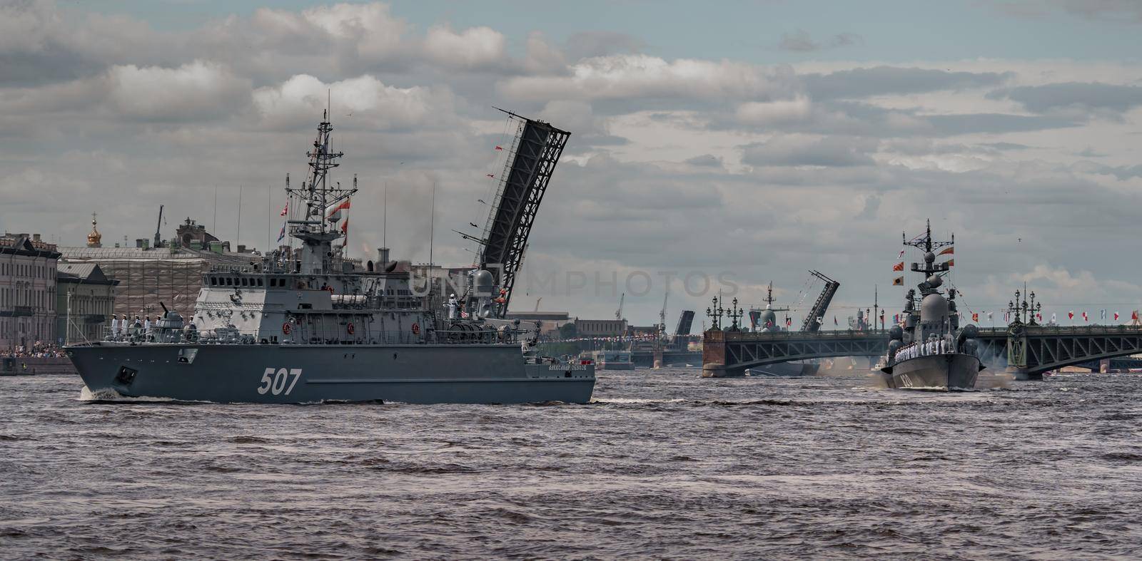 Russia, St. Petersburg, 28 July 2022: A lot of warships goes along the Neva River under open bridges at the time of the rehearsal of the celebration of the day of the Navy in sunny weather by vladimirdrozdin