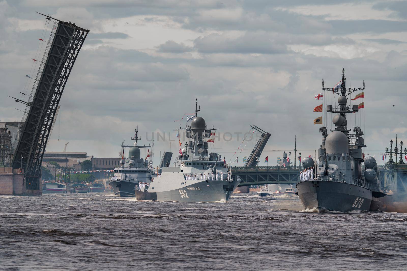 Russia, St. Petersburg, 28 July 2022: A lot of warships goes along the Neva River under open bridges at the time of the rehearsal of the celebration of the day of the Navy in sunny weather. High quality photo