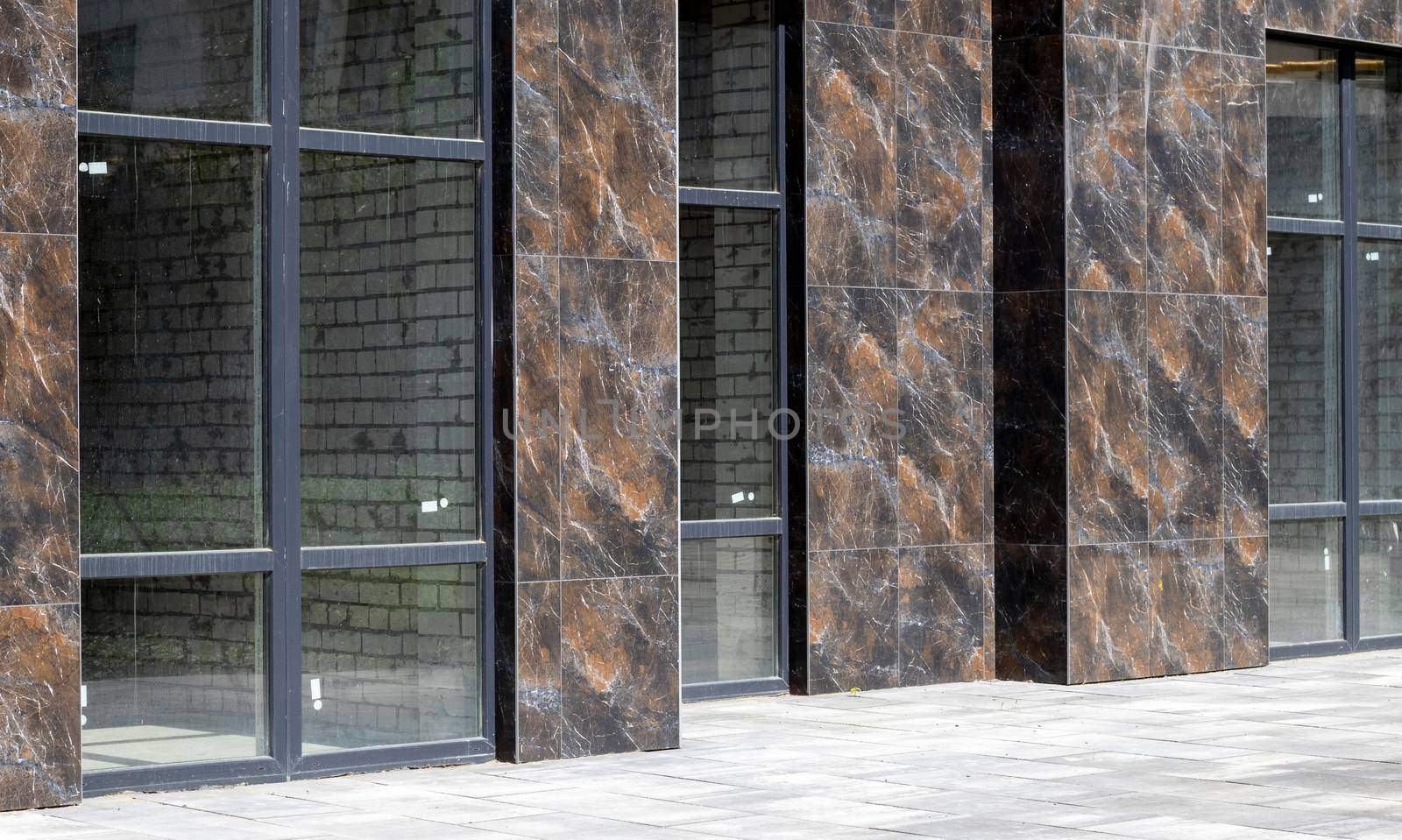 Facade of commercial premises with panoramic windows at street level in a new modern residential complex. Commercial real estate for rent in a typical building