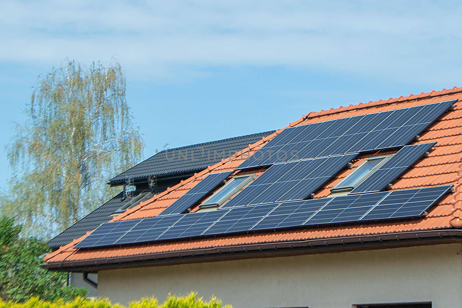 House roof with photovoltaic modules. Historic farm house with modern solar panels on roof and wall High quality photo