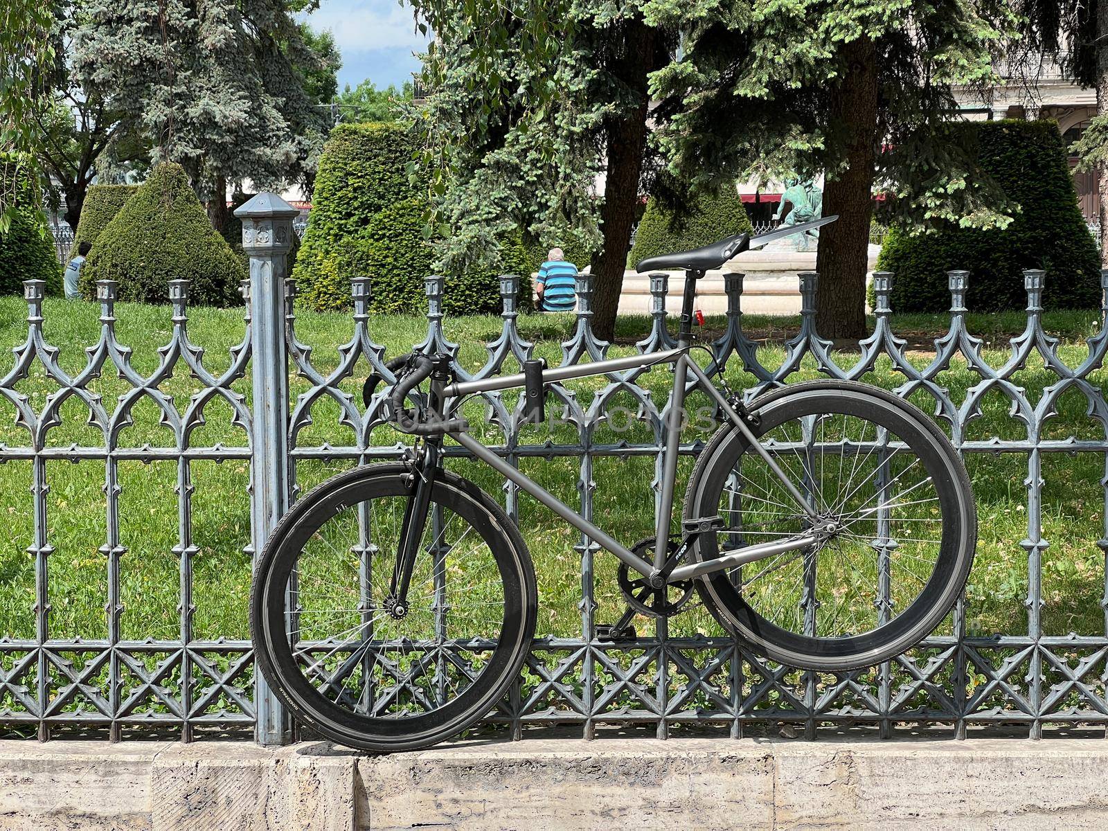 Bicycle attached to a metal fence in the park. High quality photo