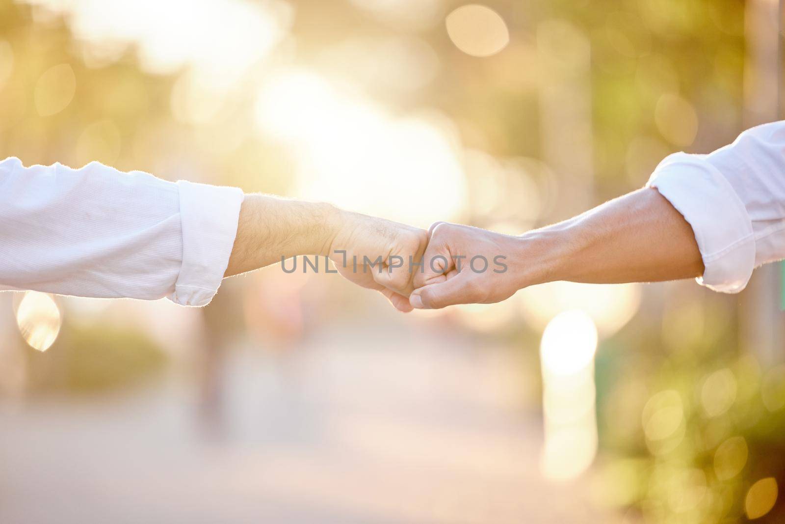 See you on Monday, bro. two unrecognizable businessmen standing in the city together and giving each other a fist bump. by YuriArcurs