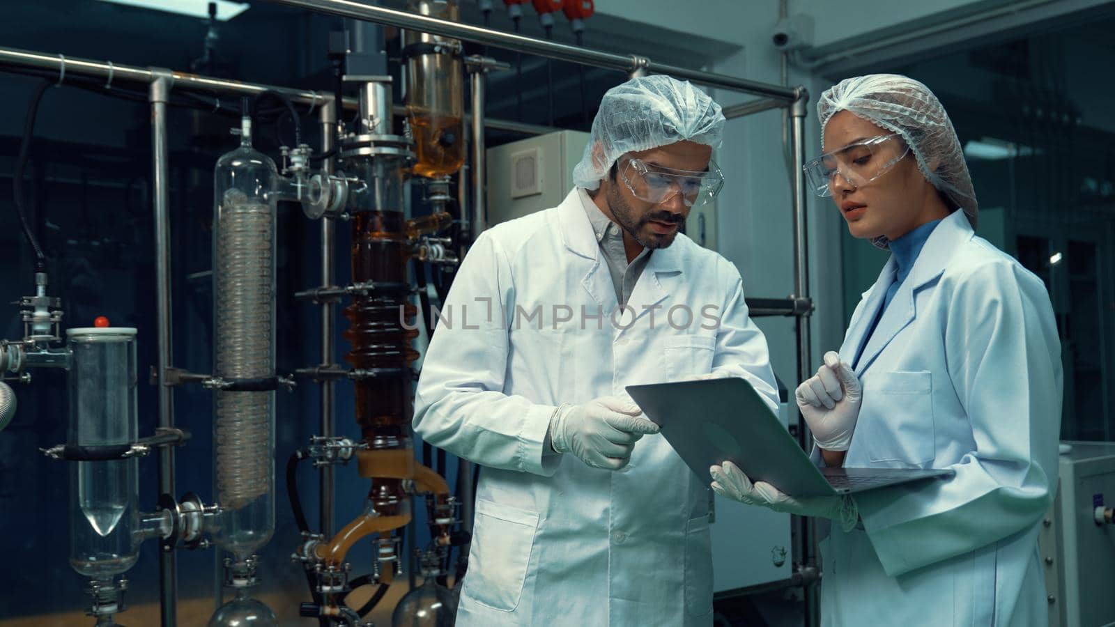 Two scientist in professional uniform working in laboratory for chemical and biomedical experiment