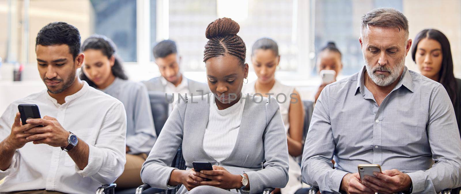 Connected, 247. a group of businesspeople using their cellphones while sitting in the office during a conference