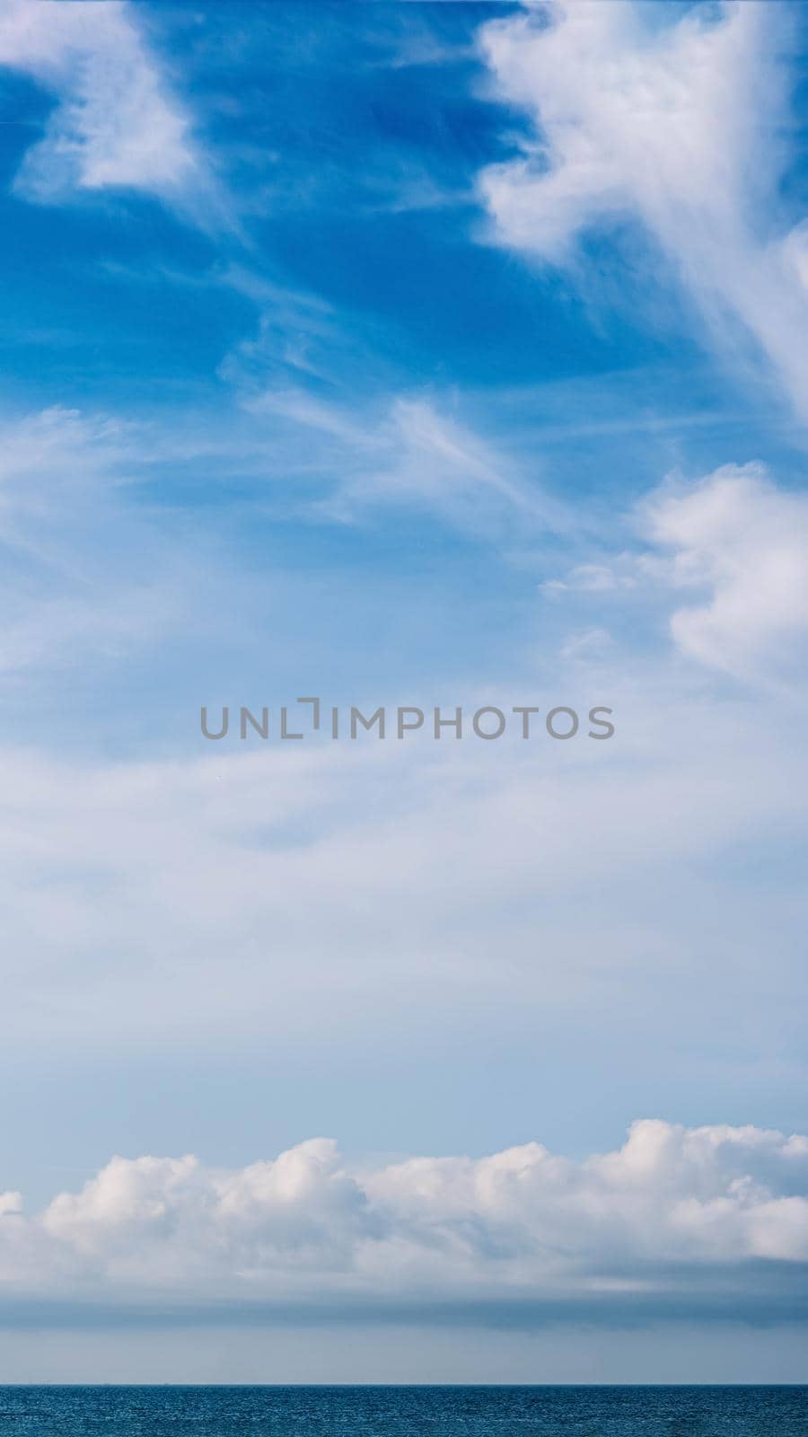 VERTICAL PANORAMA real photo natural cloudscape wallpaper. Beautiful white fluffy cumulus clouds summer blue sky calm sea horizon skyline. Concept relax mood, more size and tone collection in stock.