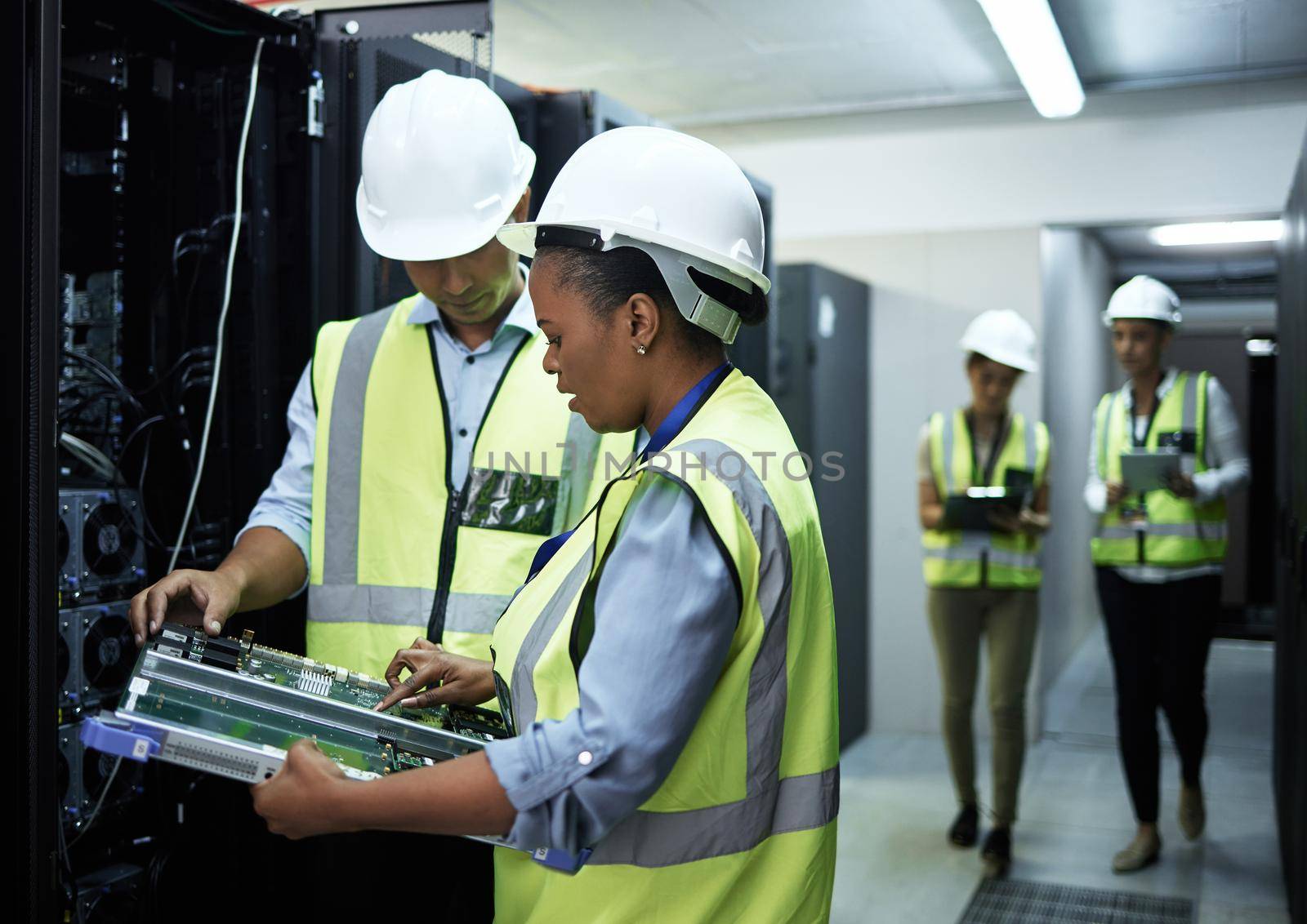 Technology doctors. a group of computer programmers working in a server room