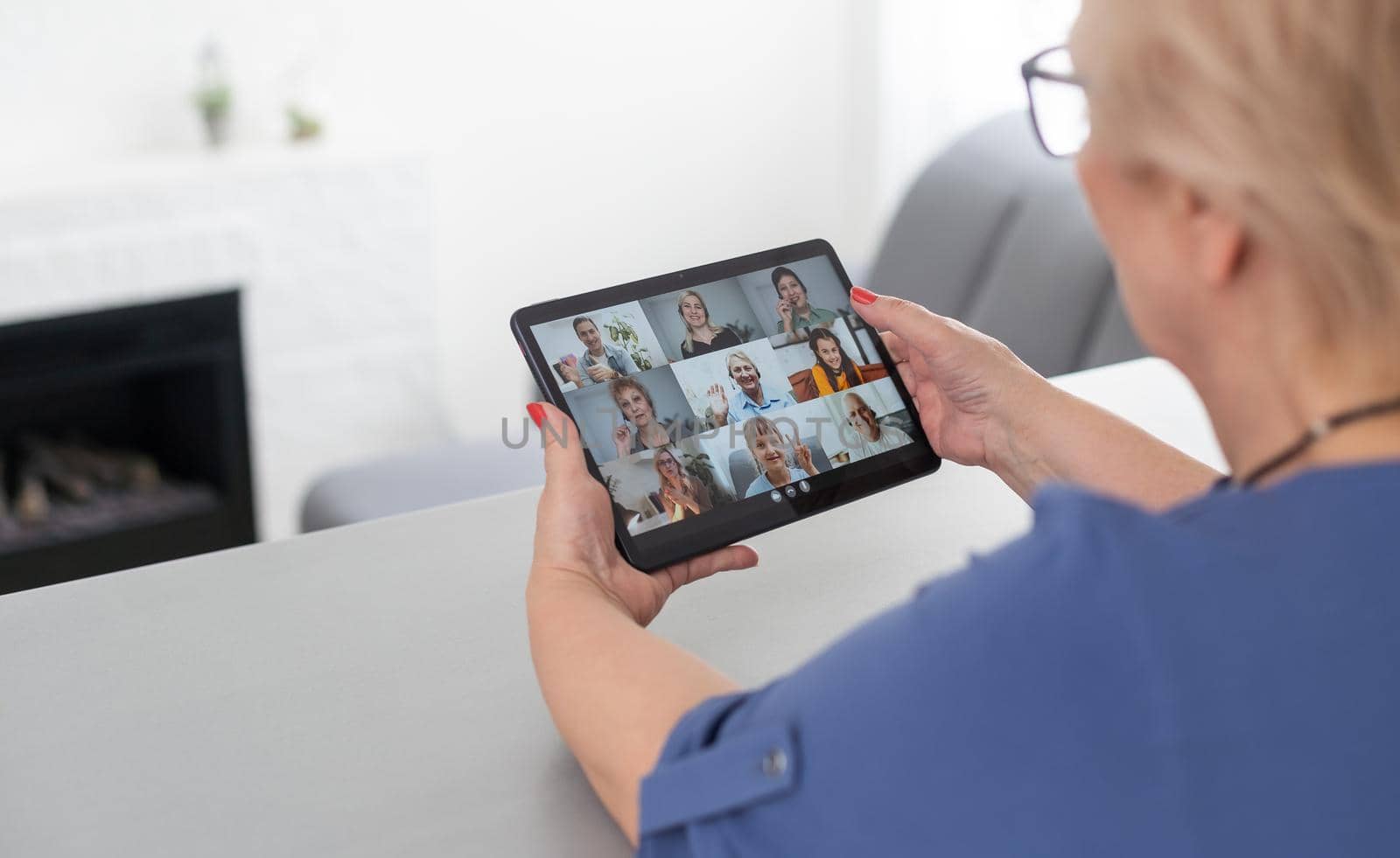 Senior woman making video call from tablet computer at home by Andelov13