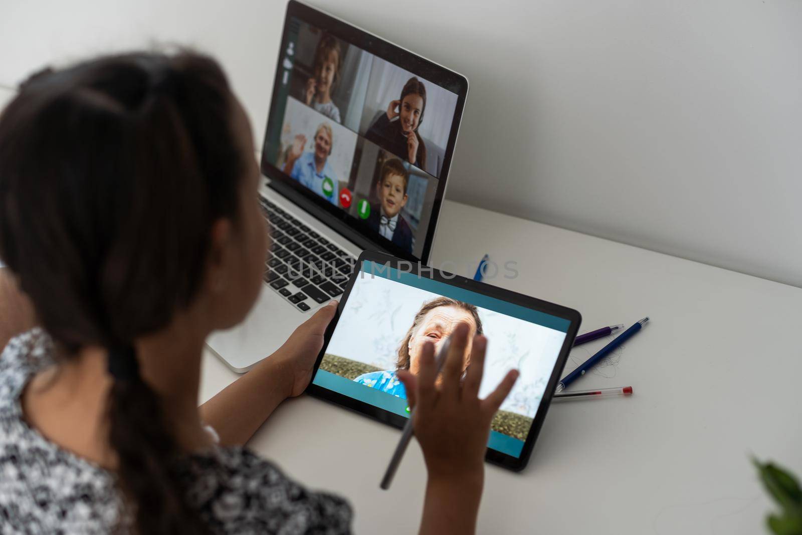 Closeup view of little girl using tablet for conversation video chat at home.