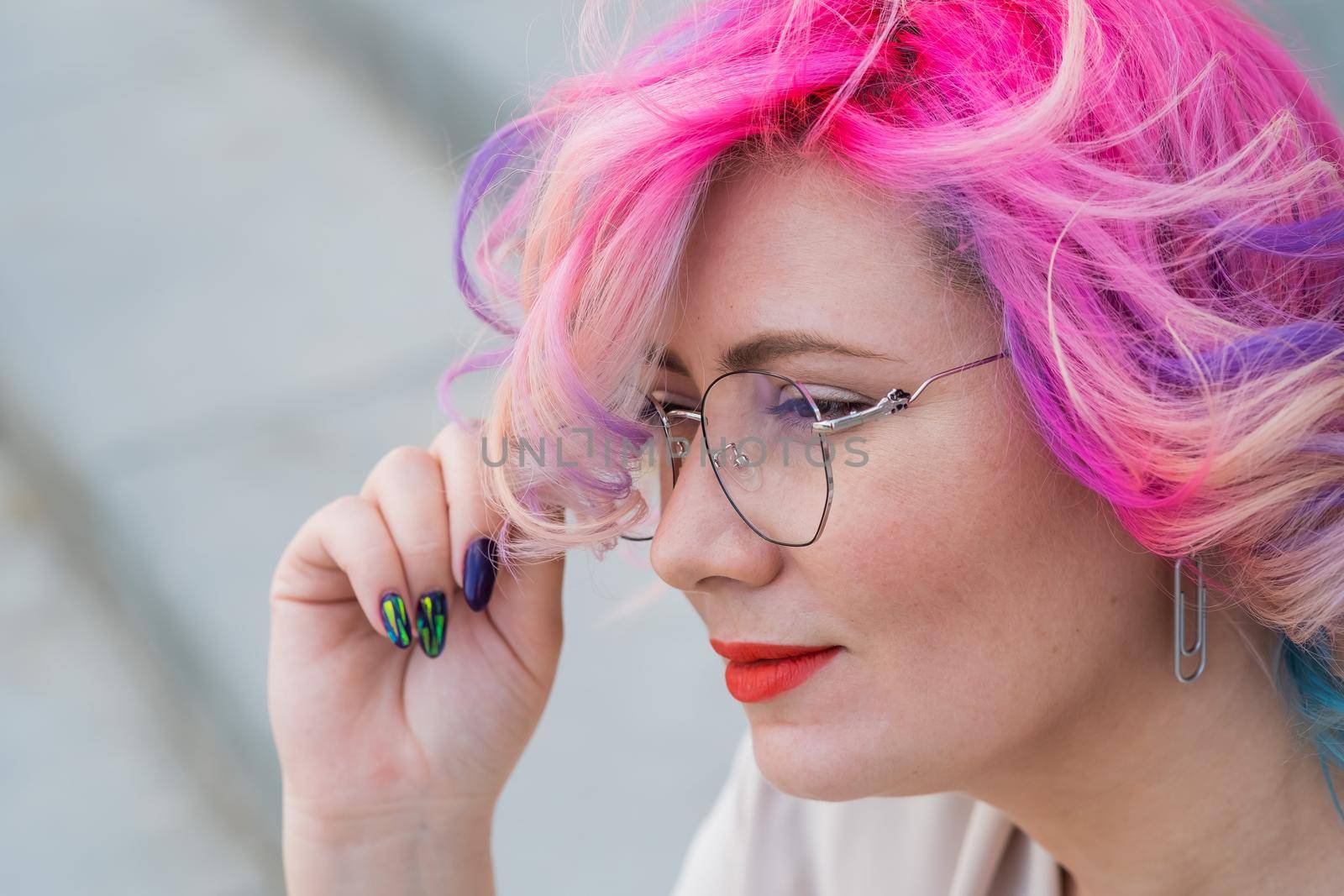 Close-up portrait of a middle-aged woman with multi-colored hairstyle.