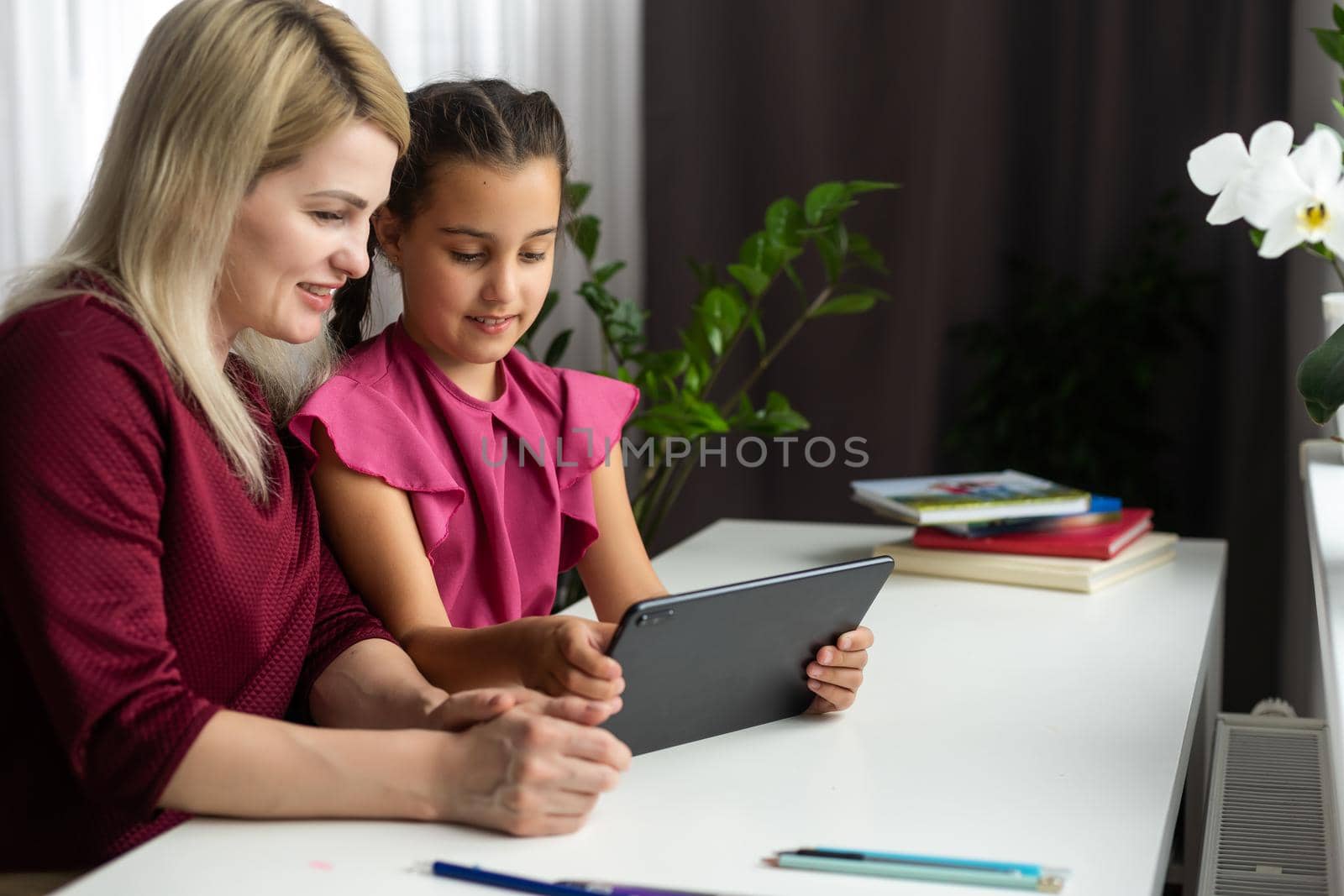 Mother and daughter playing with digital tablet.