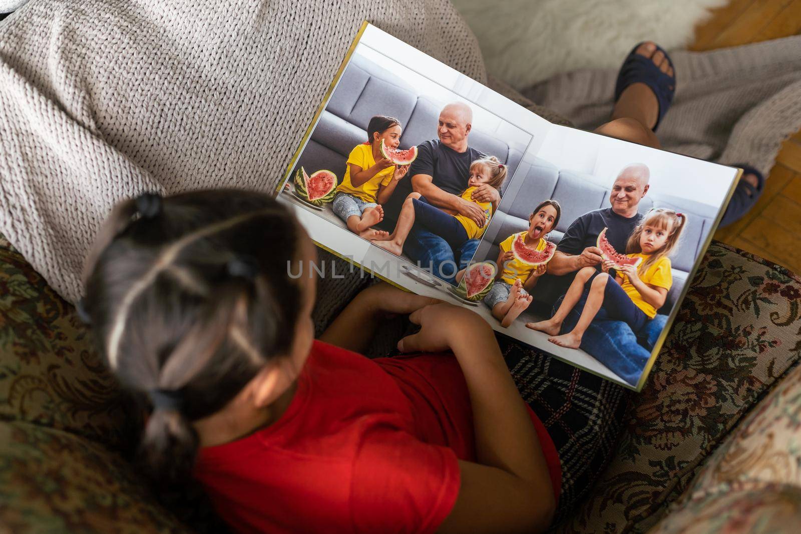 a little girl is holding a photo book.