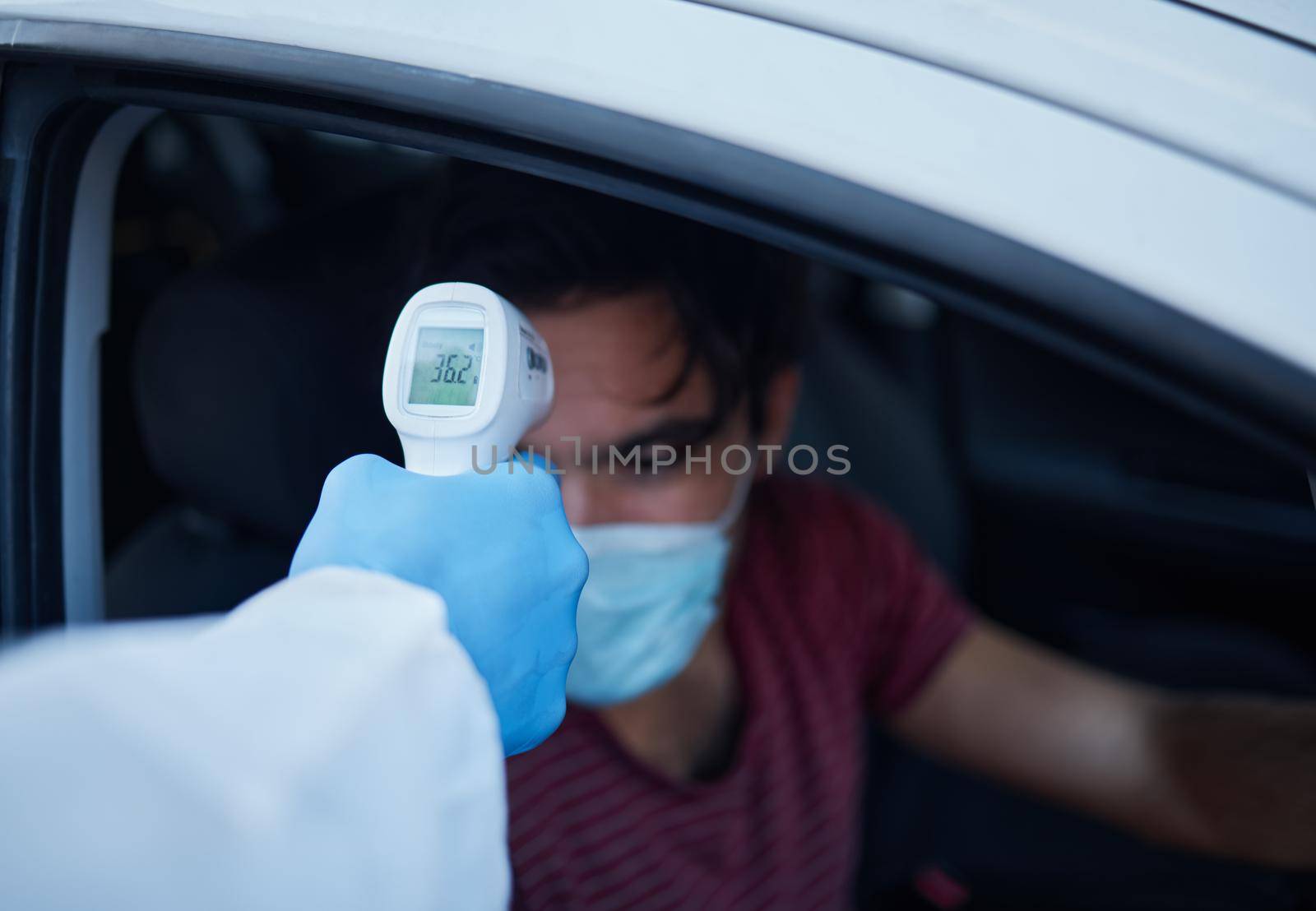 Your temperature seems to be good. a man getting his temperature taken. by YuriArcurs