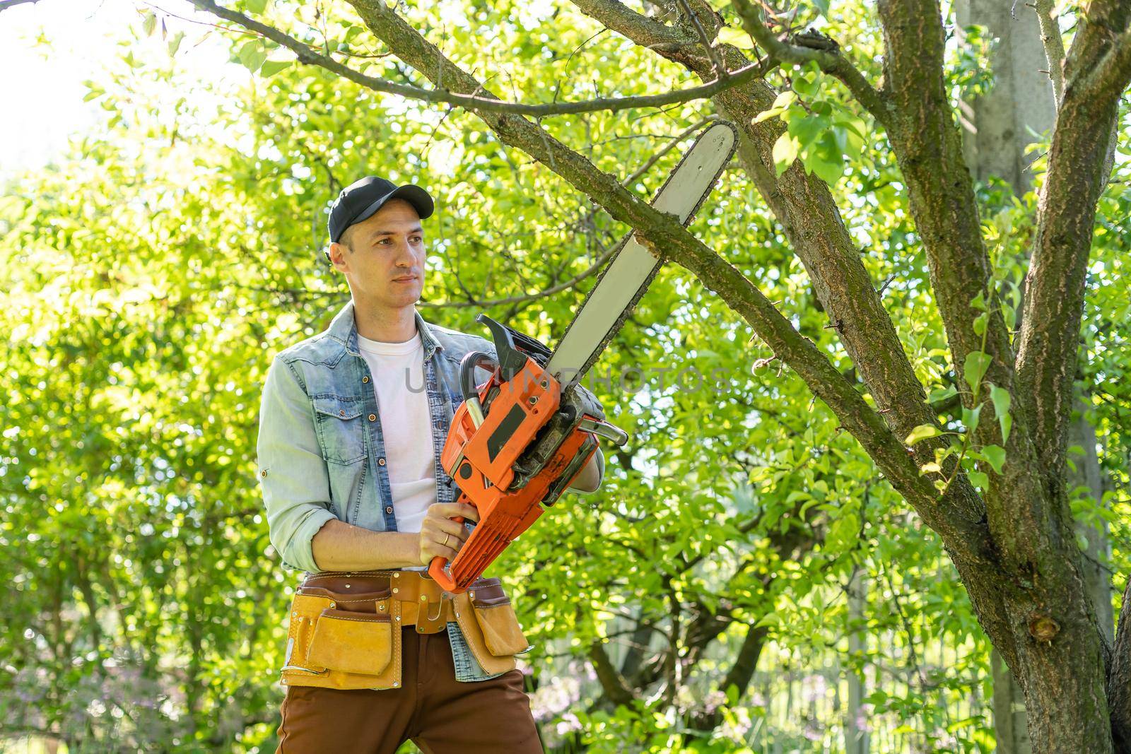 man sawing branches with a chainsaw. Concept of a professional logging.