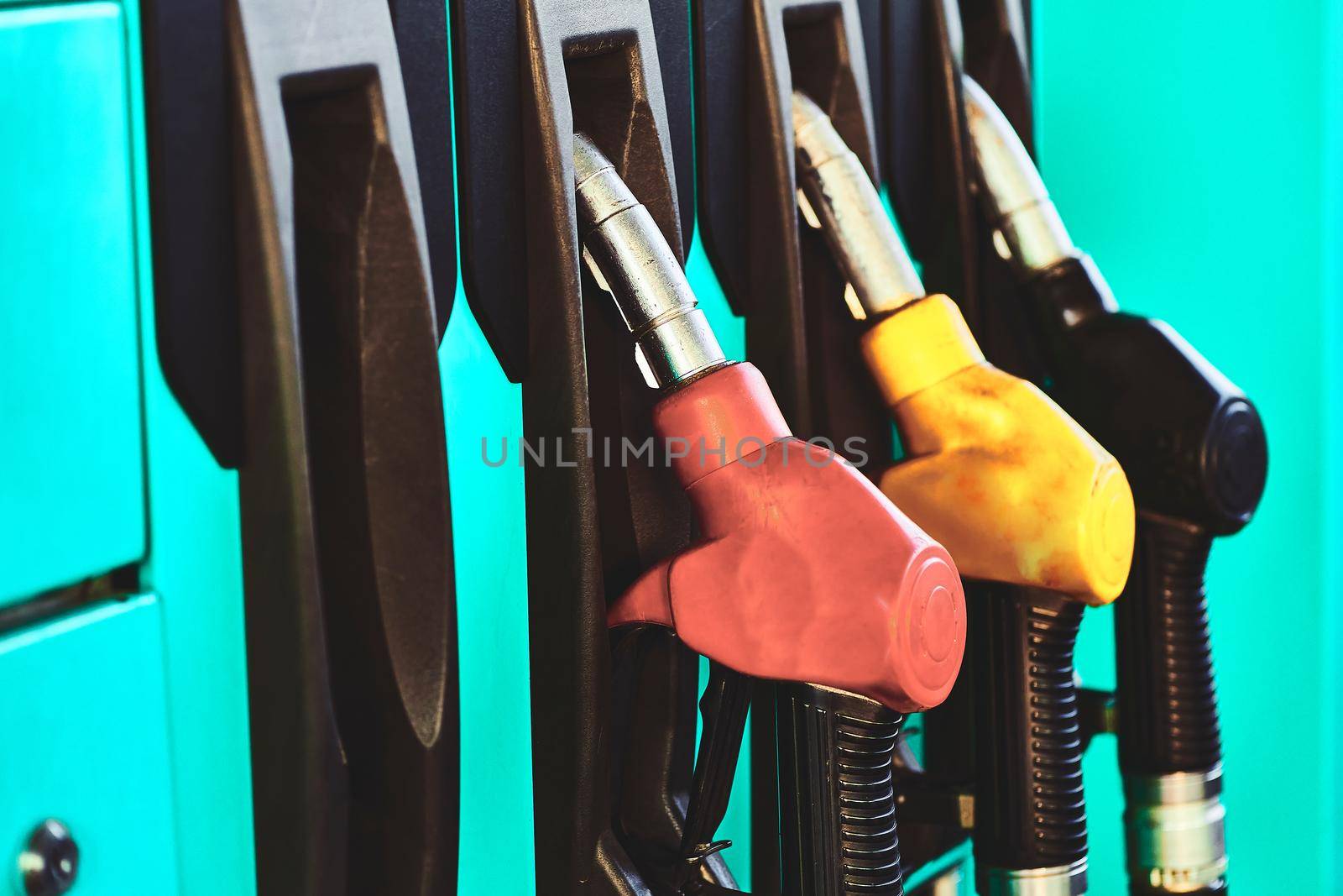 A refueling gun wakes up a car at a gas station. by jovani68