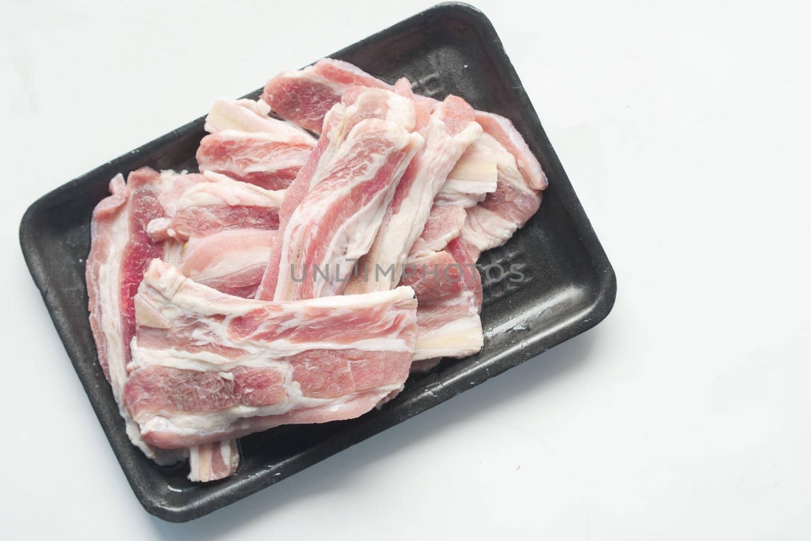 Raw fed bacon strips on white background ,