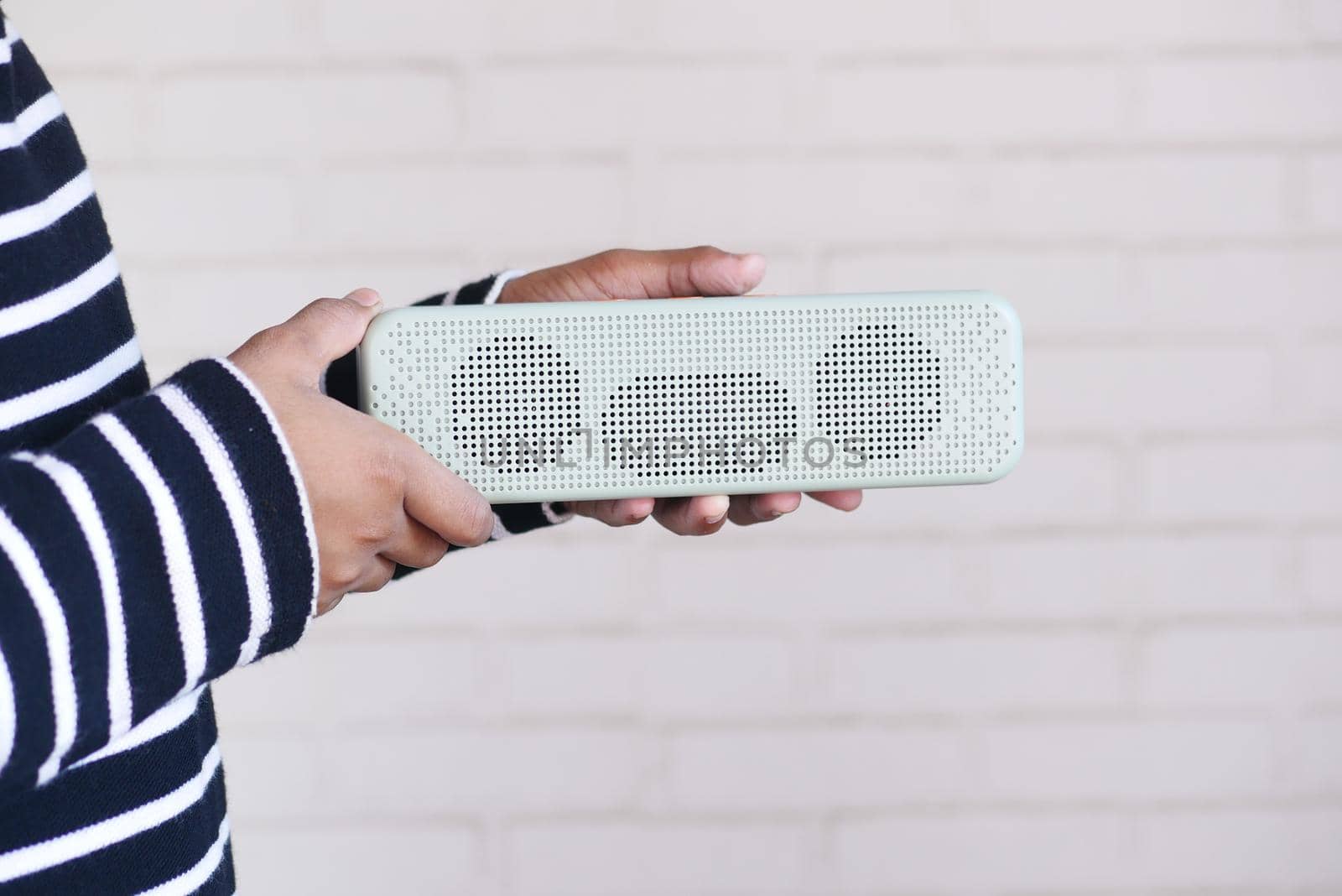 man's hand using smart speaker on table .