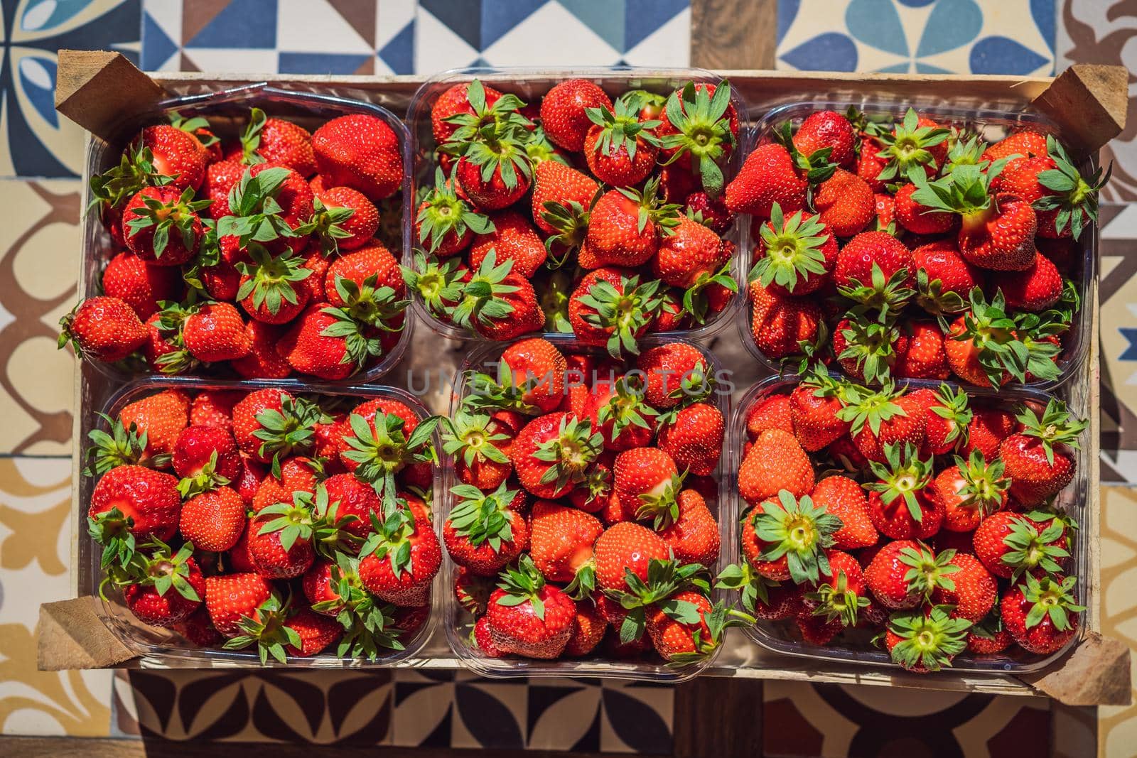 wooden box full of fresh organic strawberries on white background. top view.