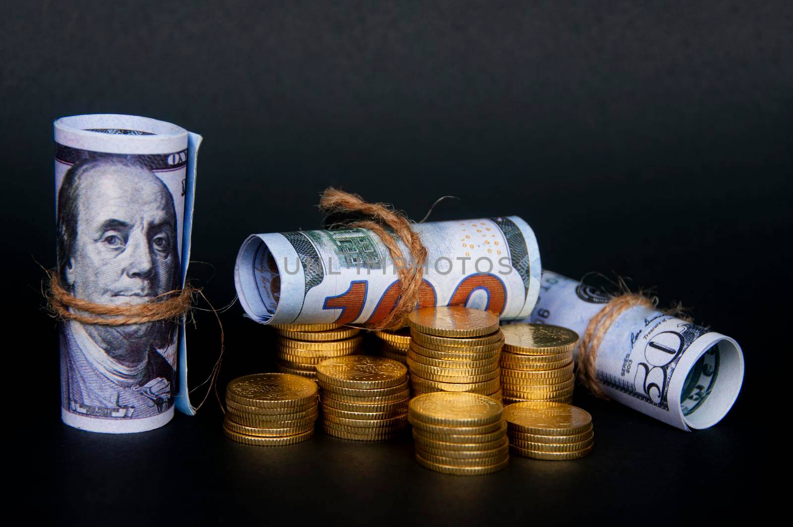 Gold coins and bank notes isolated on dark background. Copy space and business concept
