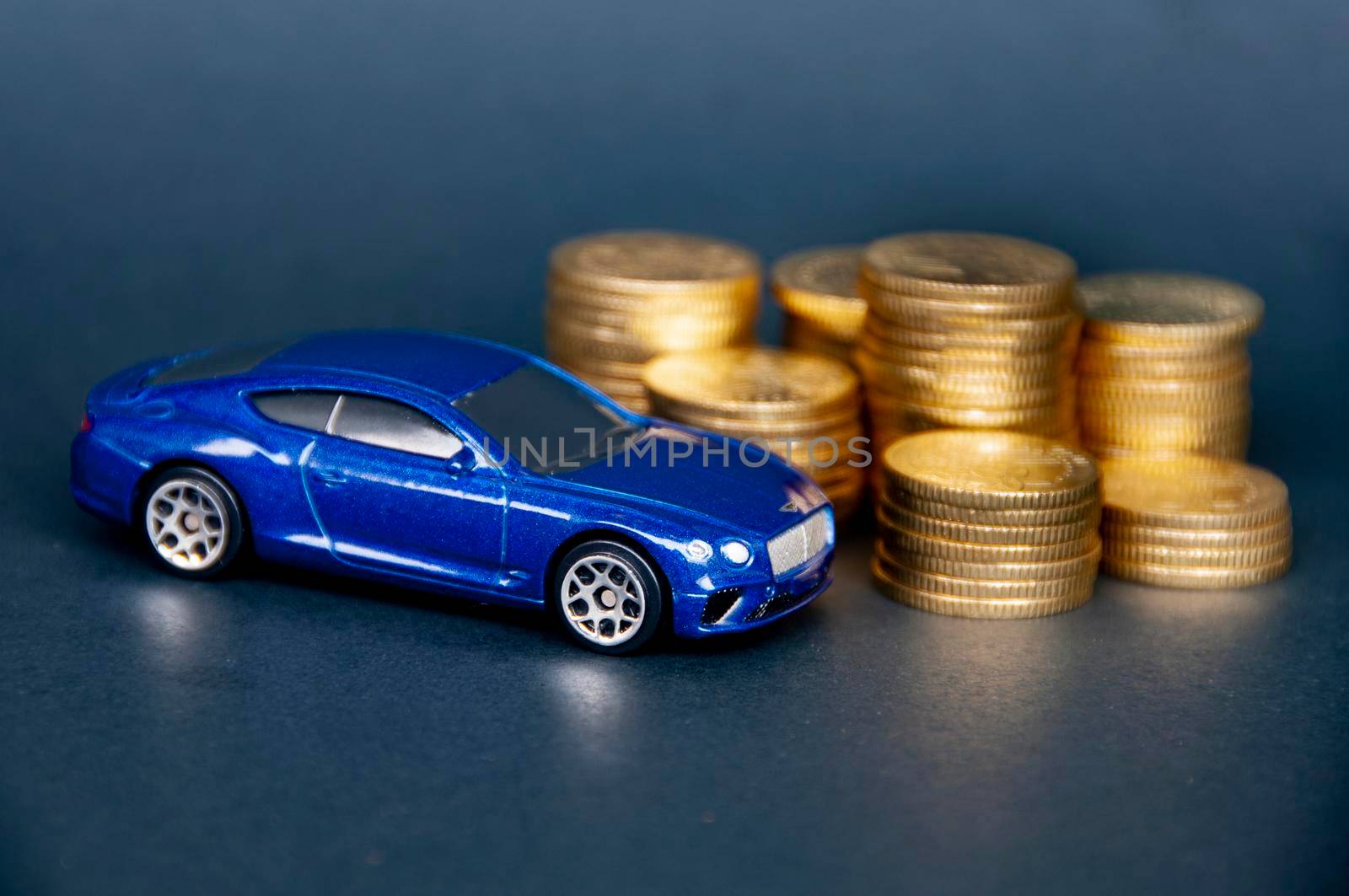 Kuala Lumpur, Malaysia - July 2022 : Miniature toy car of Bentley Continental GT with gold coins on black cover background. Copy space.