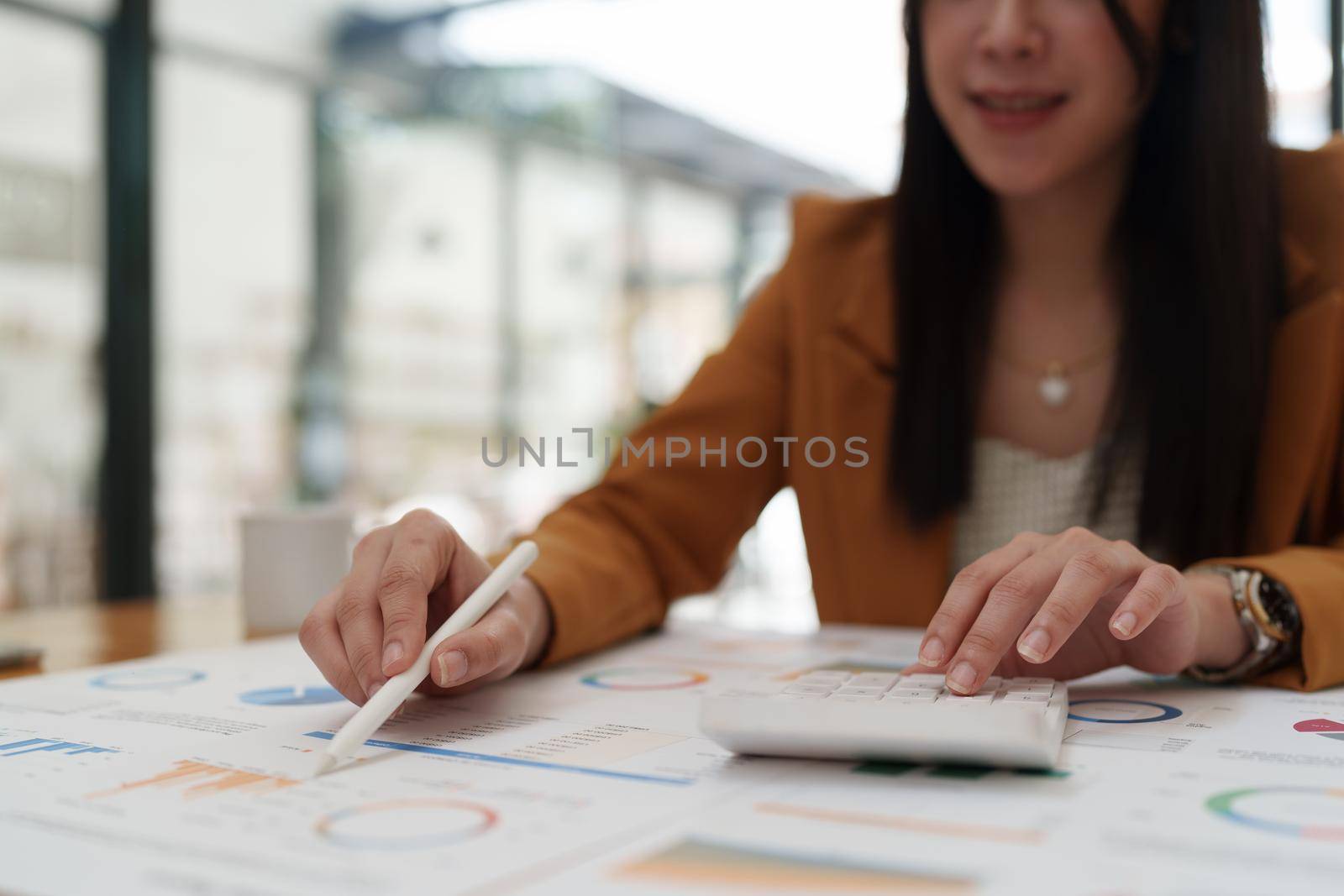 Attractive Asian business woman working with a laptop to audit financial at office. Account concept