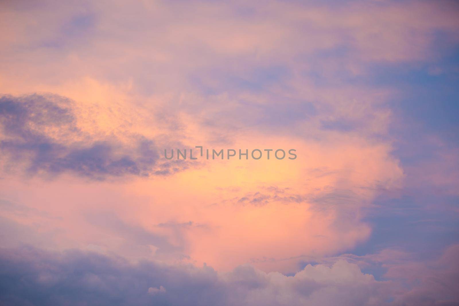 Sunset sky with colorful clouds. Blue colors merge with soft orange.