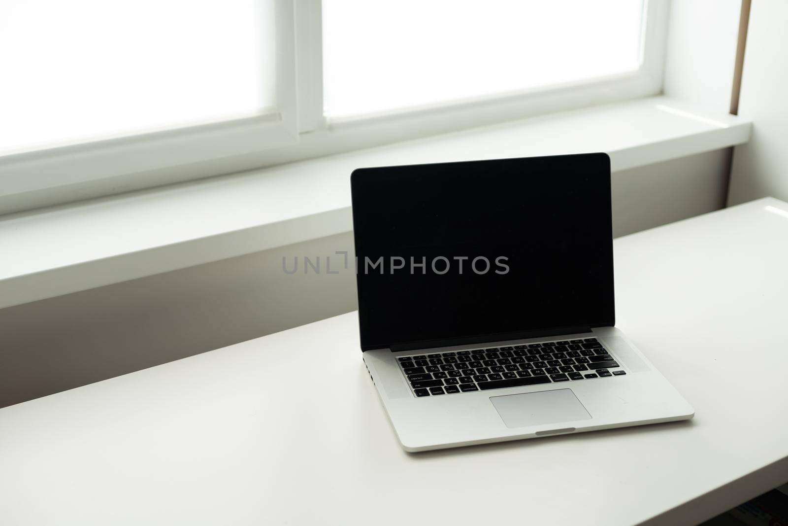 Horizontal photo of minimal workplace with computer laptop on white desk