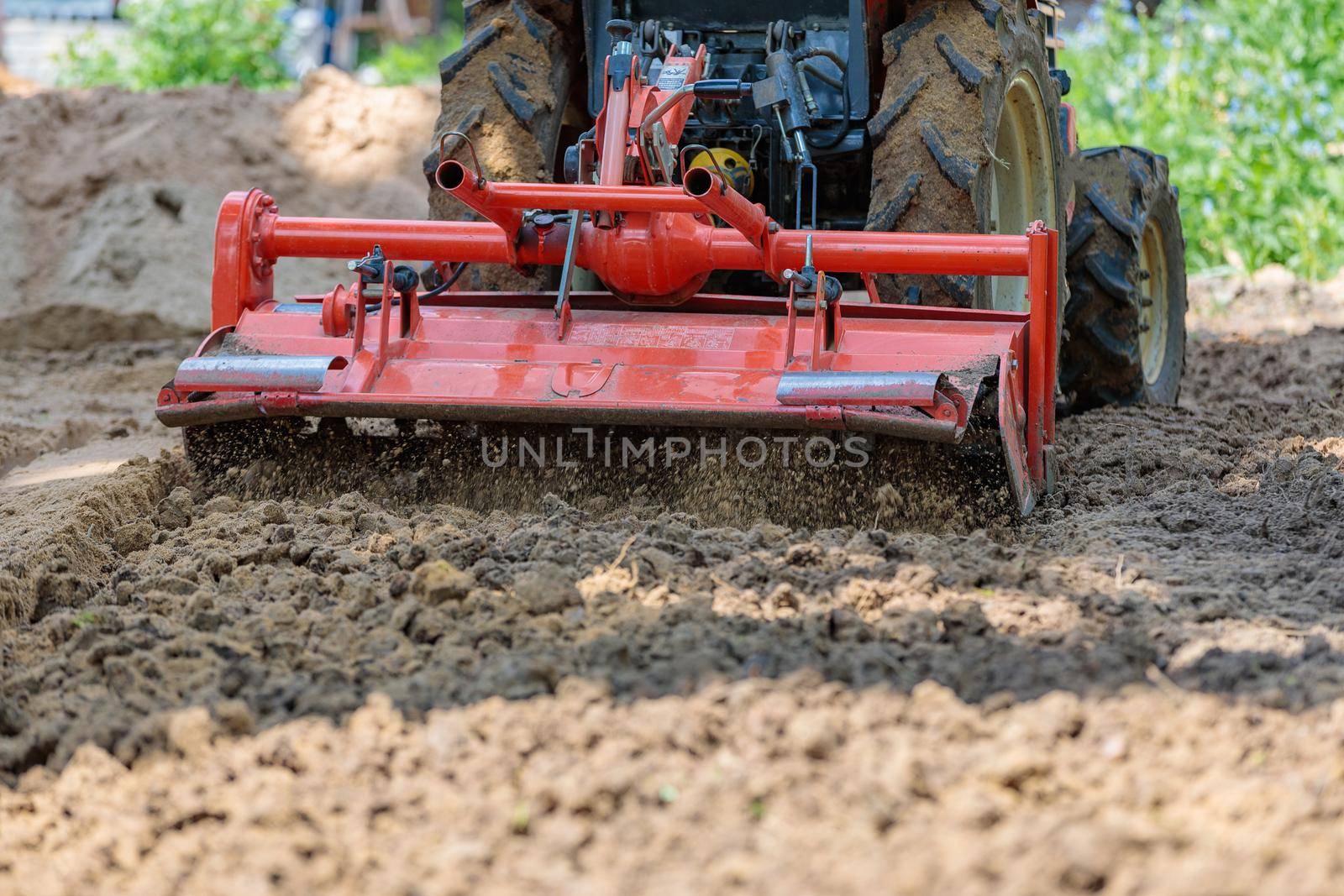 Cultivator for a mini-tractor for loosening the soil. Agricultural work. Excavation. Close-up.