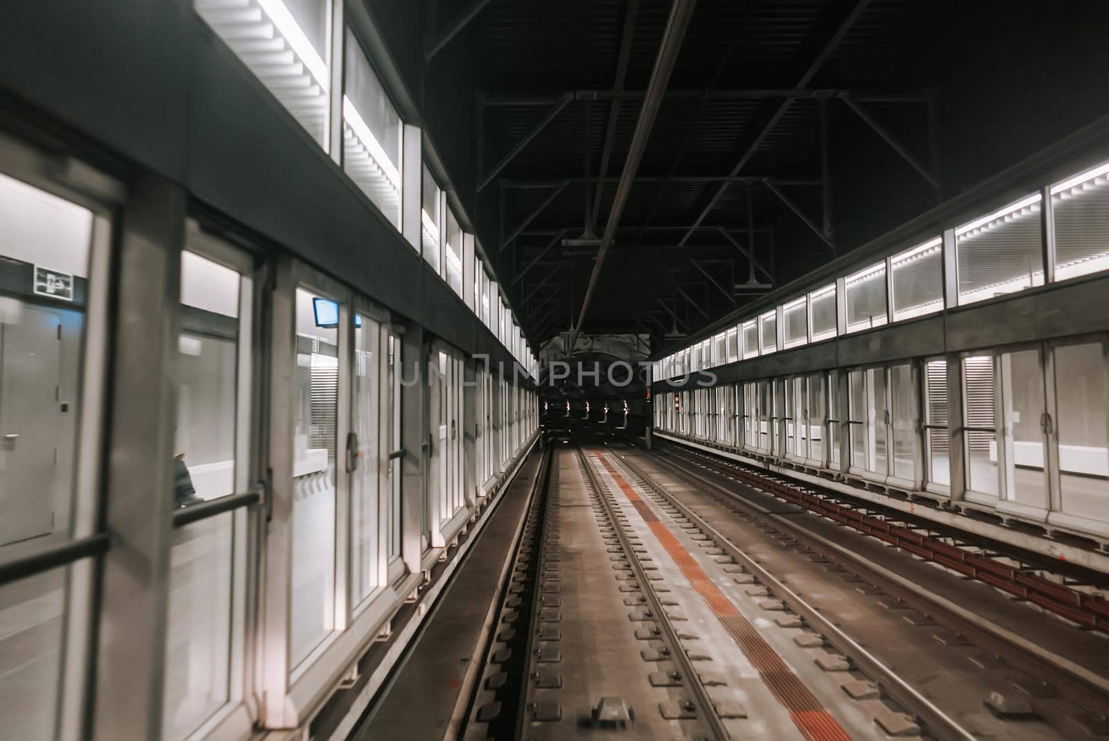 Front cabin view of moving subway carriage between airport terminals. Riding driverless metro train in Barcelona. Advanced transportation system, underground tunnel. High quality photo