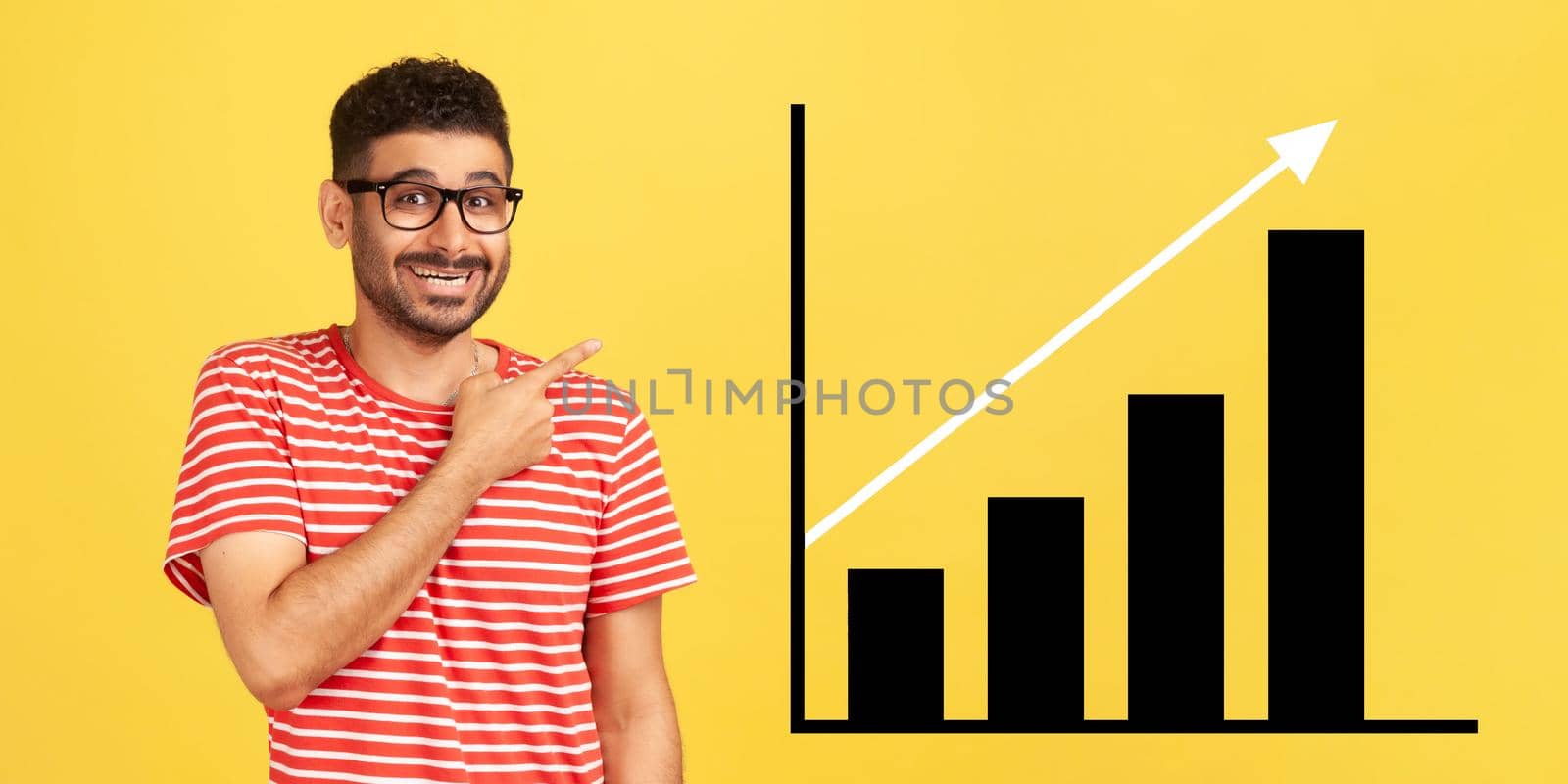 happy joyful young bearded man standing, pointing aside and showing business growth graph. by Khosro1