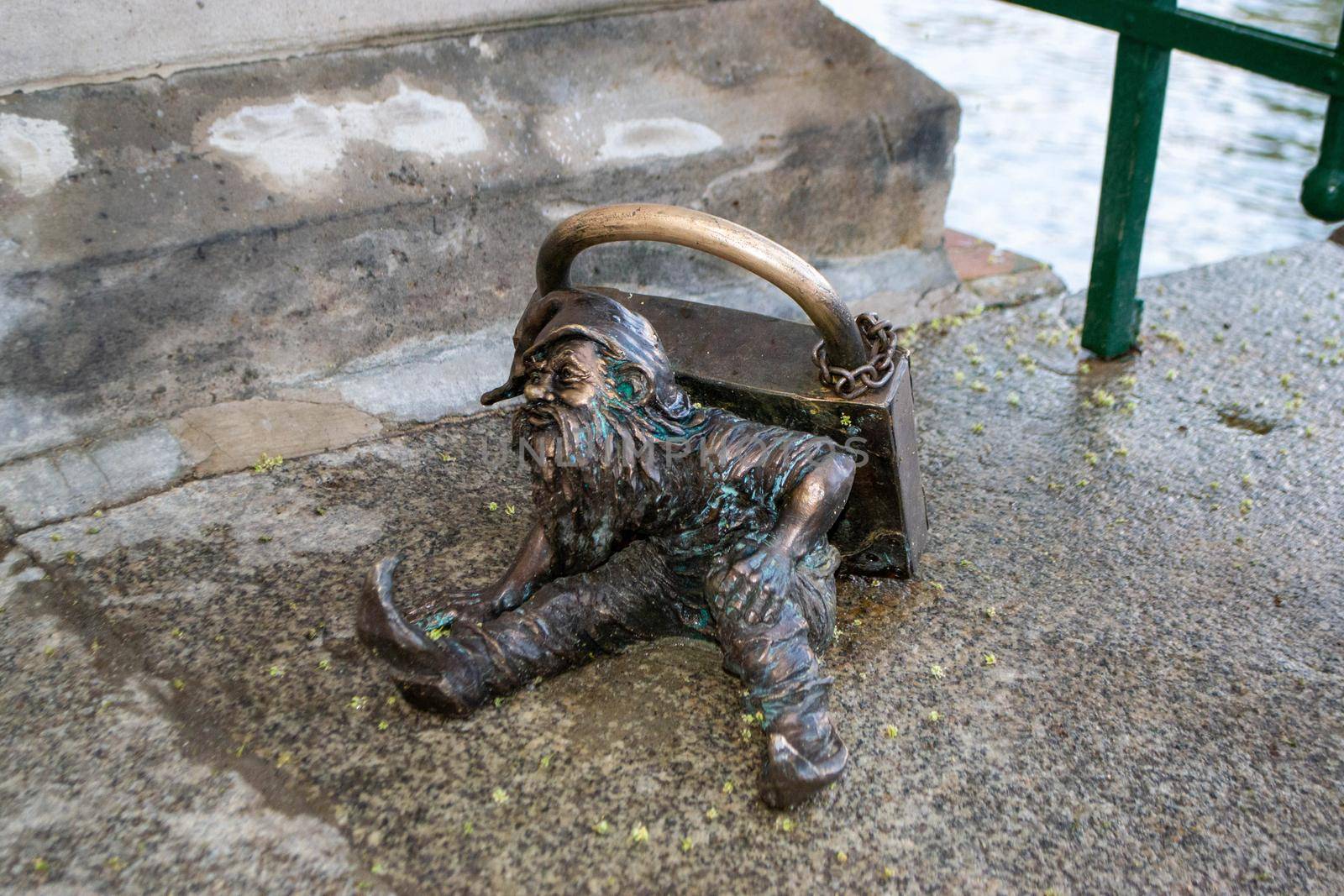 Dwarf gnomes sculpture with magnifying glass in downtown of famous polish city. Wroclaw Houses and streets of the city of Wroclaw. Cityscape. High quality photo