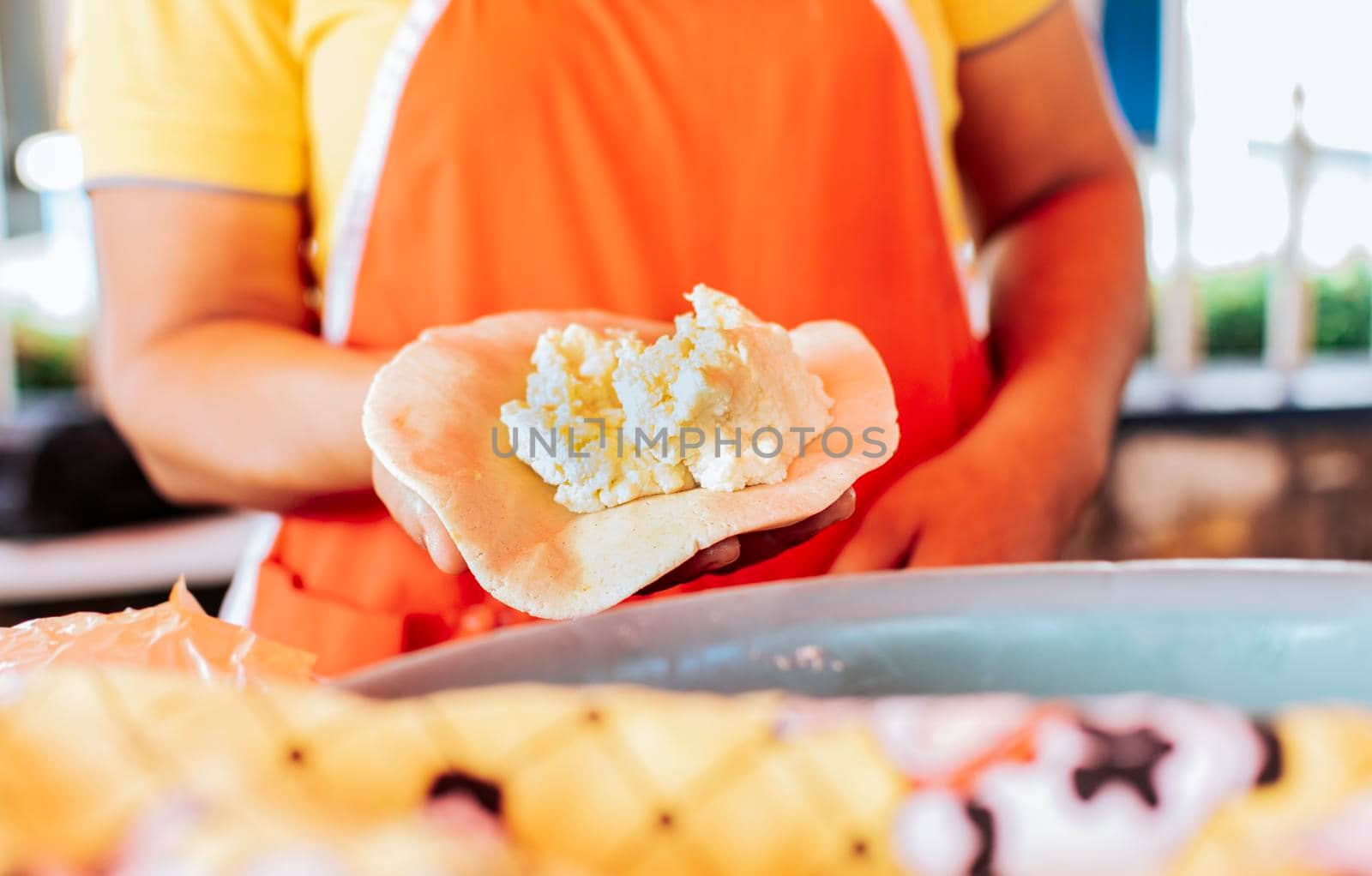 Hands of a vendor showing traditional raw pupusa. Elaboration of traditional pupusas, elaboration of the dough for traditional Nicaraguan pupusas by isaiphoto