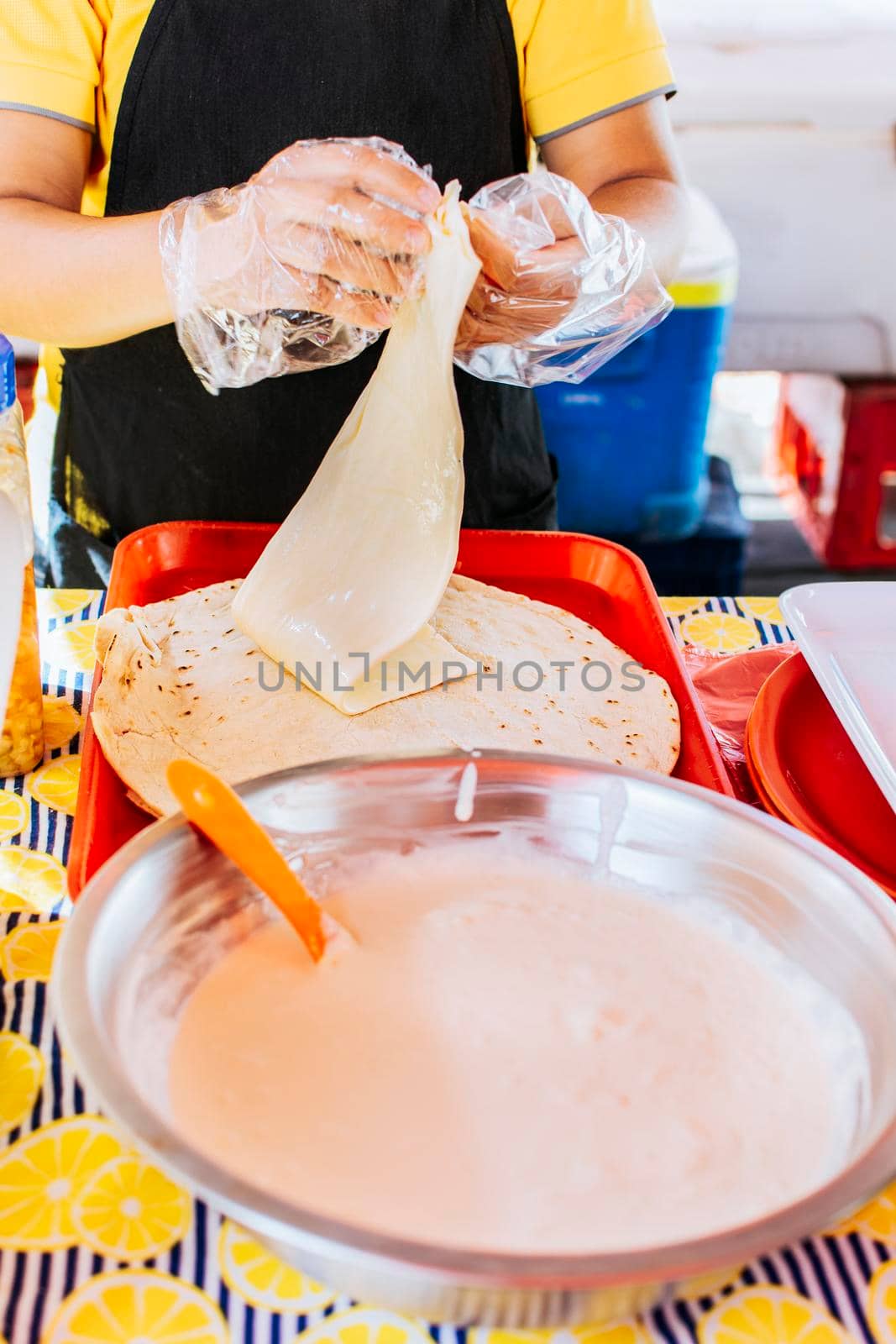 Preparation of Nicaraguan QUESILLO, traditional Central American food quesillo. Hands making a Nicaraguan quesillo. Close up of hands making a traditional quesillo with pickled onion. by isaiphoto