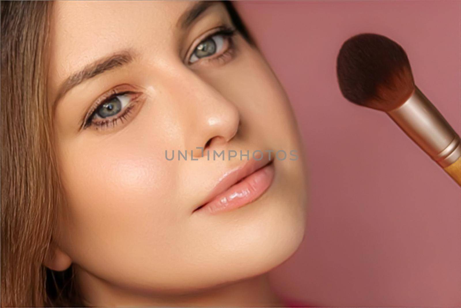 Beautiful young woman applying cosmetic powder product with make-up bamboo brush, beauty, makeup and skincare cosmetics model face portrait on pink background by Anneleven