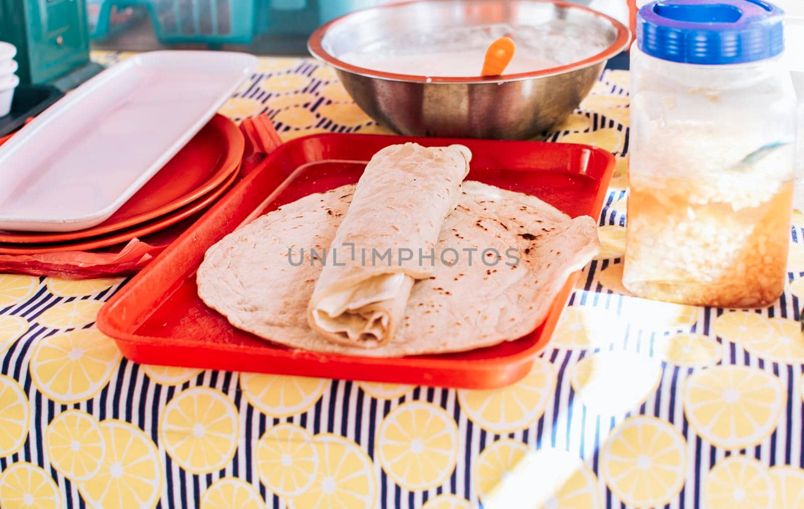 Nicaraguan quesillo made and served on the table. Traditional quesillo with pickled onion and wrapped tortilla. Traditional Nicaraguan Quesillo, food Traditional Large Quesillo served on table.