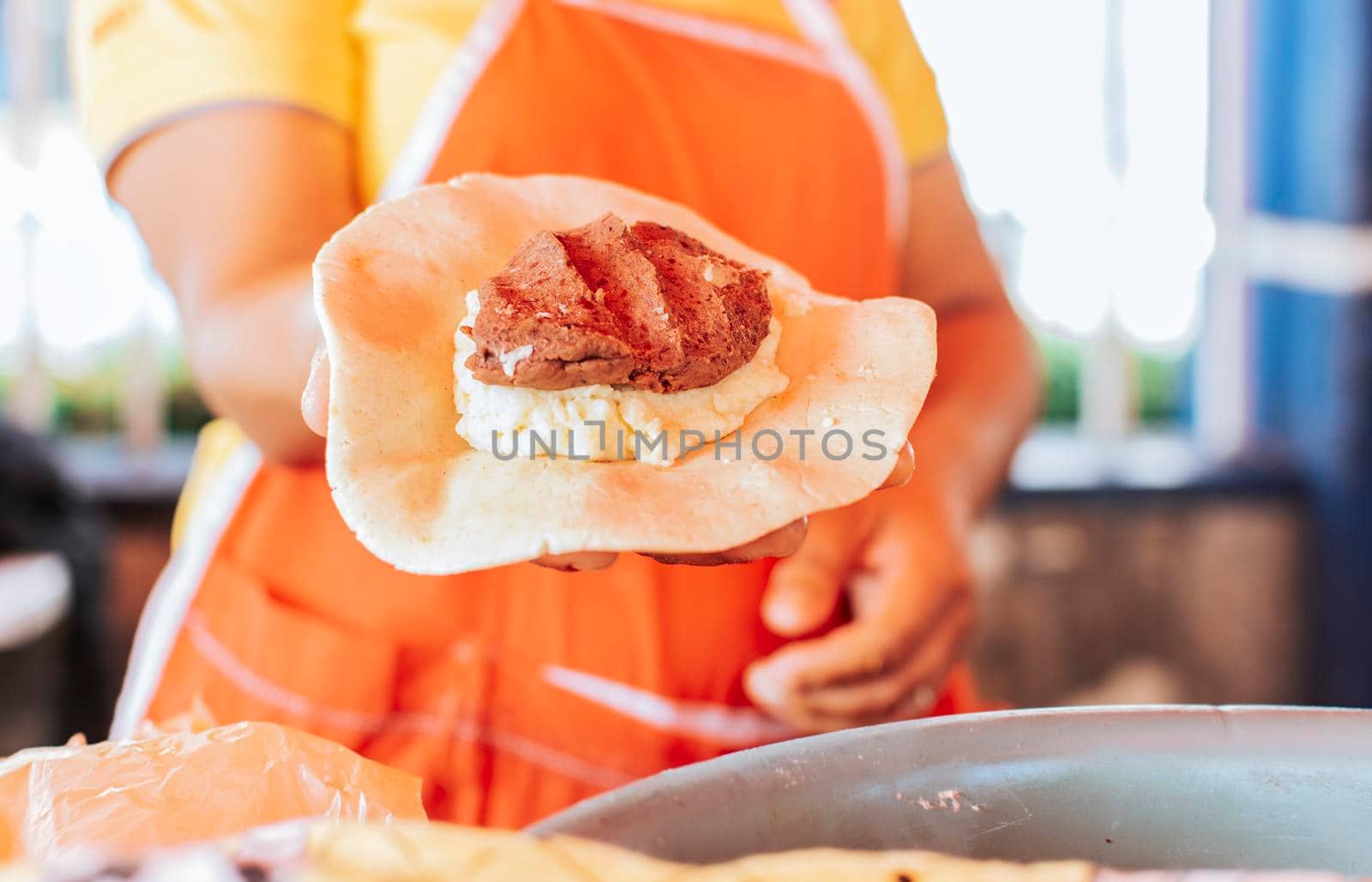 Preparation of the dough for traditional Nicaraguan pupusas, Elaboration of traditional mixed pupusas, Hands of a vendor showing traditional raw pupusa.