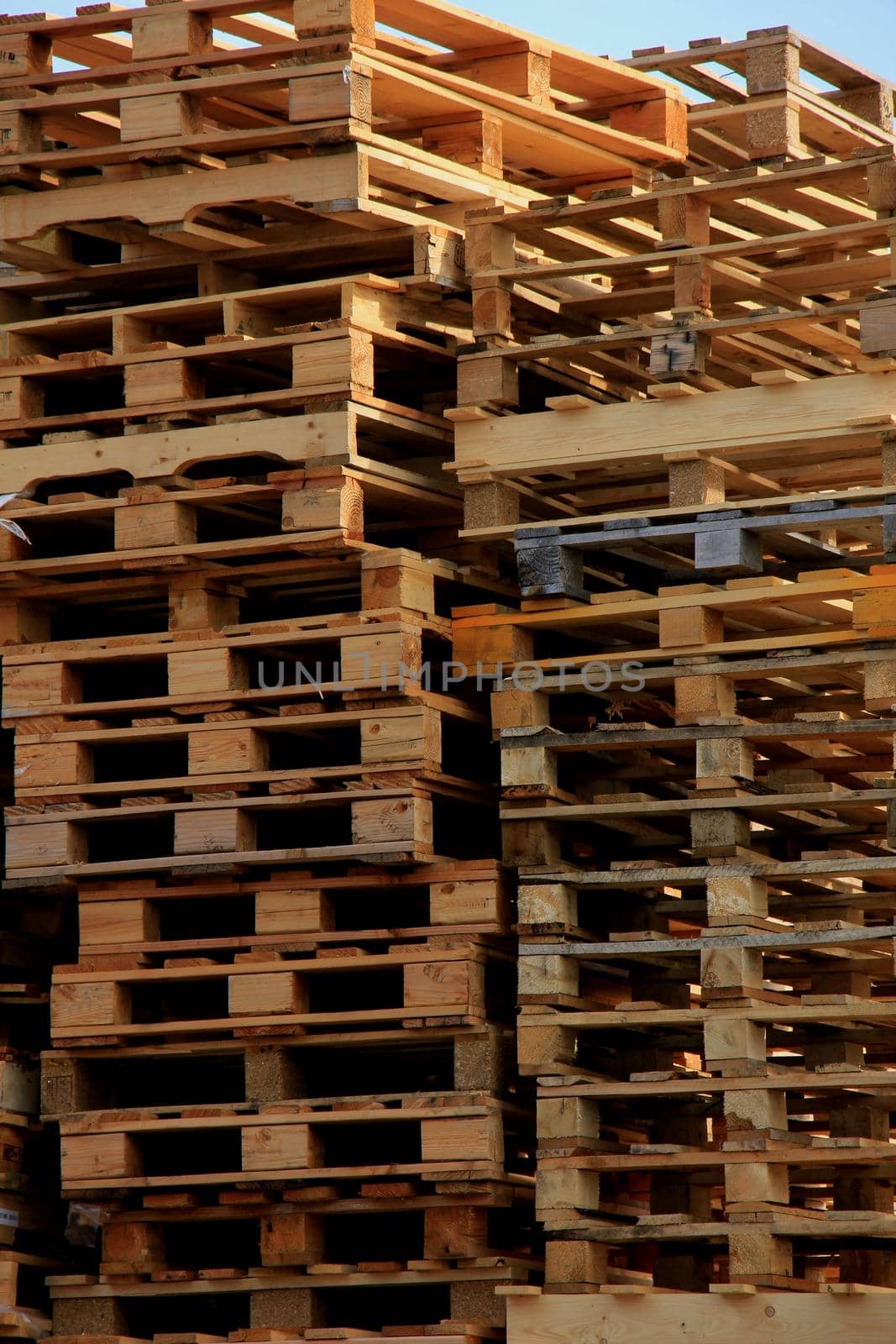 Stacked wooden pallets at a pallet storage by studioportosabbia