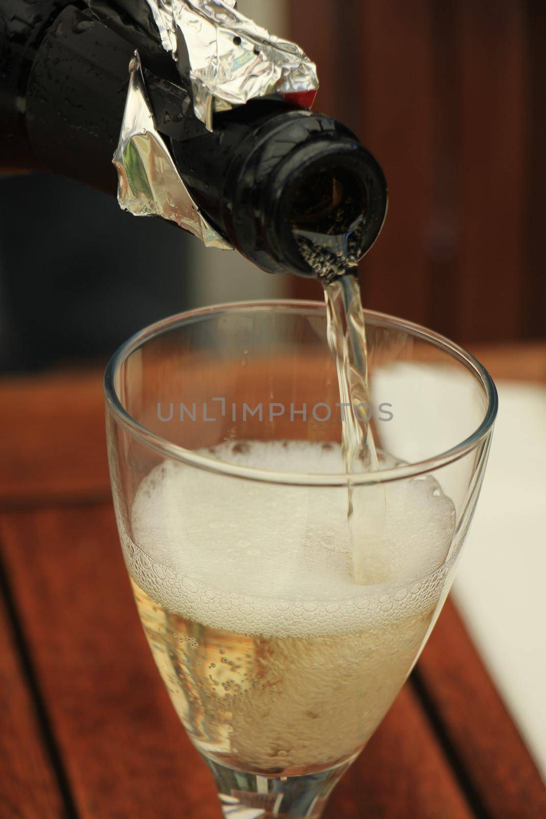 Man pouring white wine at a dinner table