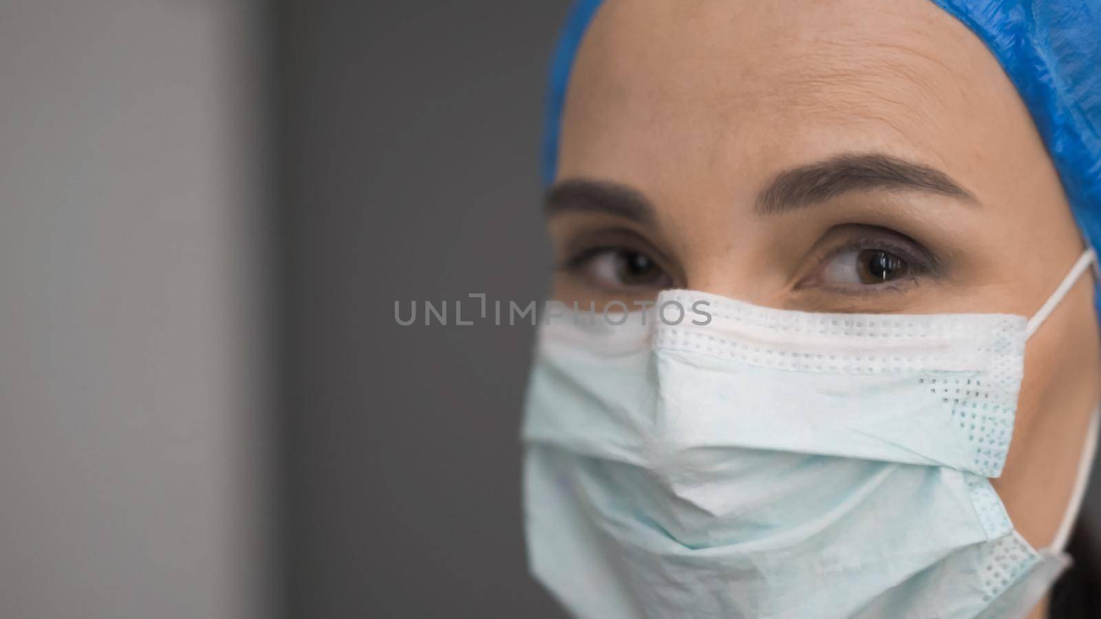 Female Medic In Protective Mask Looks At Camera by LipikStockMedia