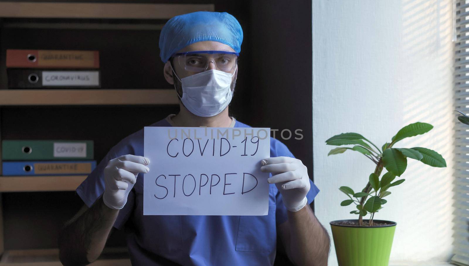 Medic Shows Inscription That Covid-19 Virus Is Stopped by LipikStockMedia